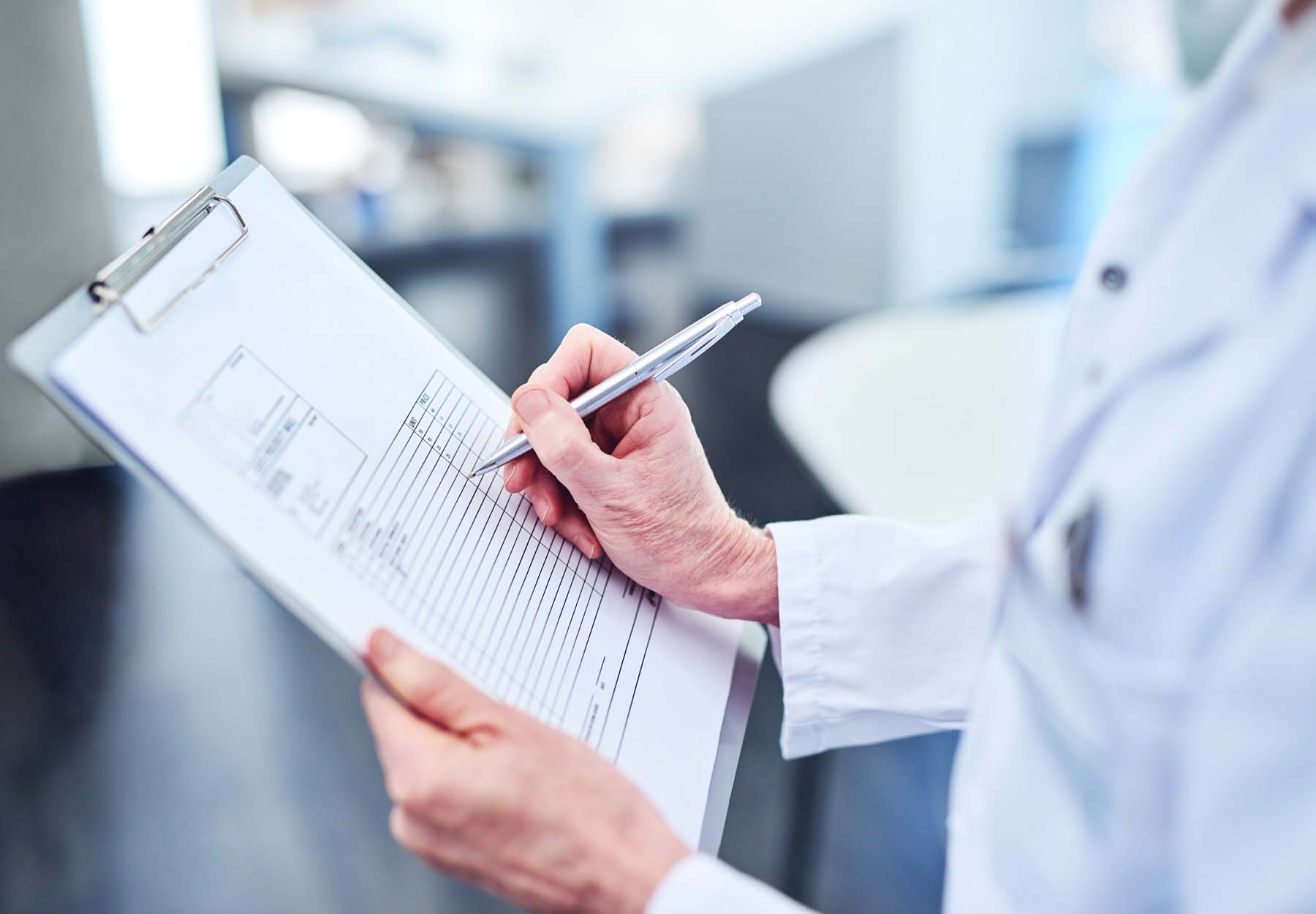 A lab professional filling out an injury/illness report in the lab.