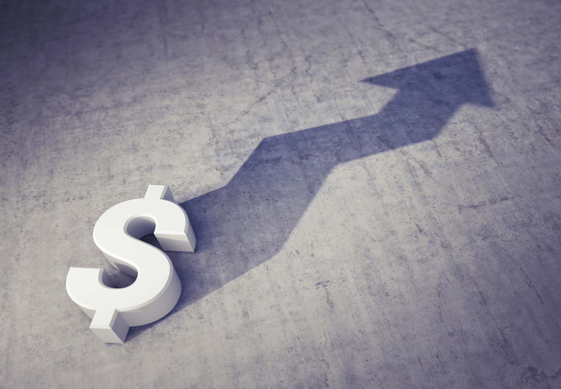A white dollar sign on a grey background with the shadow of a rising arrow to illustrate rising costs or recoveries.