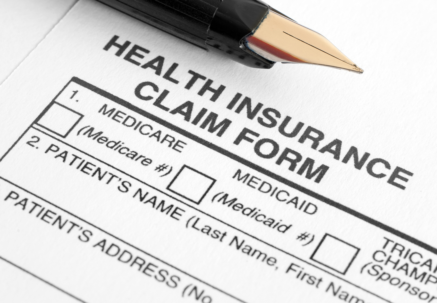 An image of a health insurance claim form with a pen on top of it.