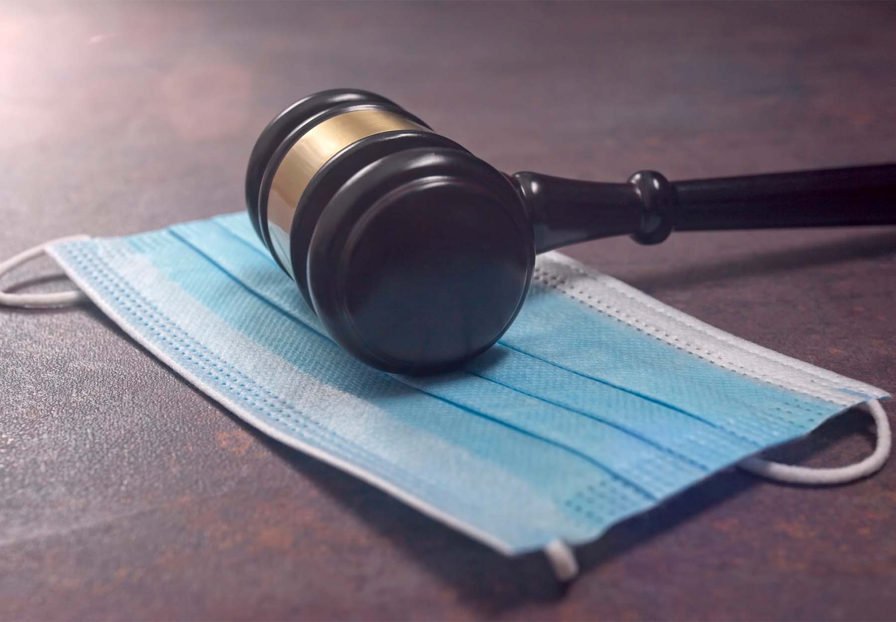 A gavel on a medical mask.