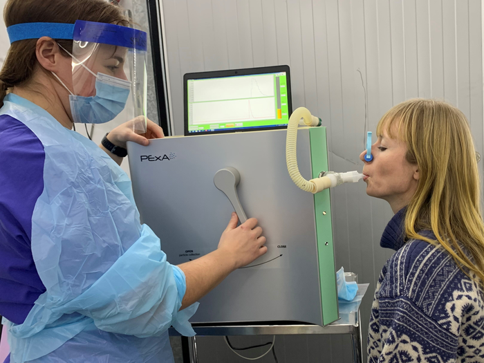 A researcher and participant test the detection of SARS-CoV-2 with a device at the University of Gothenburg