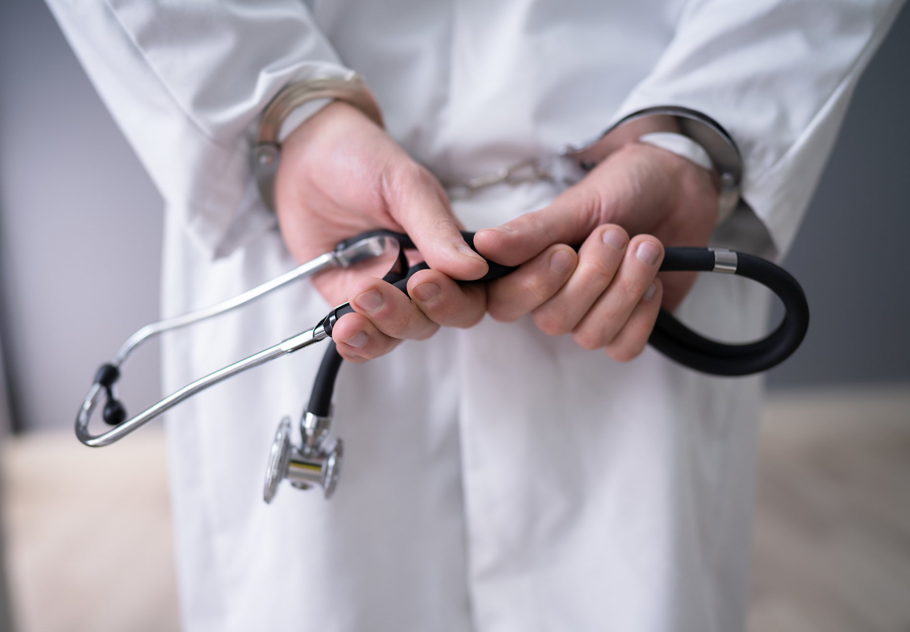 Close-up Of Doctor Hands With Stethoscope In Handcuffs