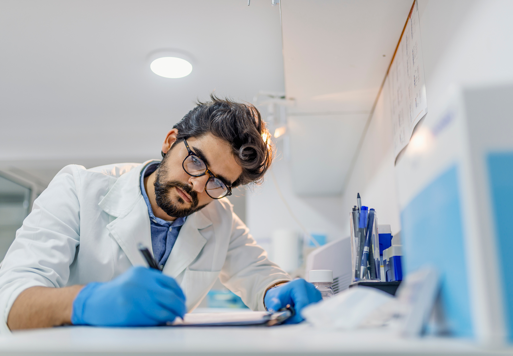 A lab worker filling out a form in the laboratory.