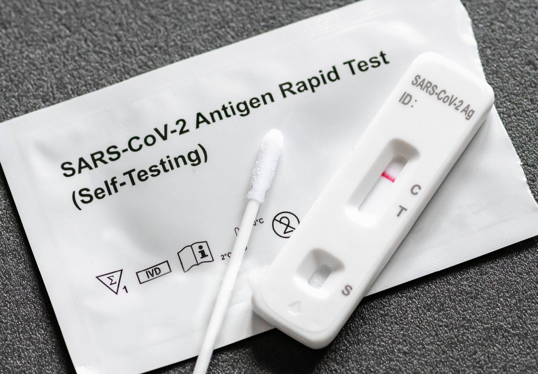 A stock image of a SARS-CoV-2 antigen rapid test next to a swab.