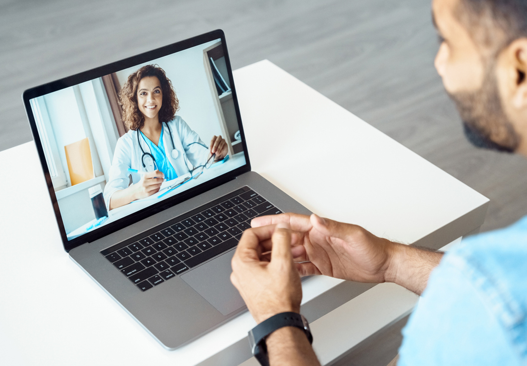 A man speaks to his doctor over a video conference call on his laptop.