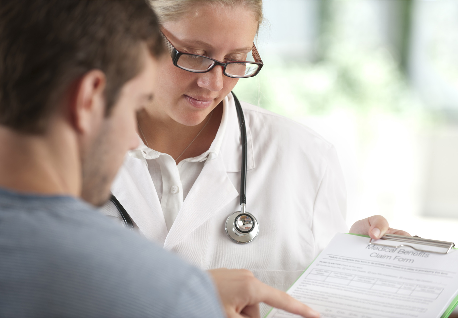 A doctor helps a patient fill out a form