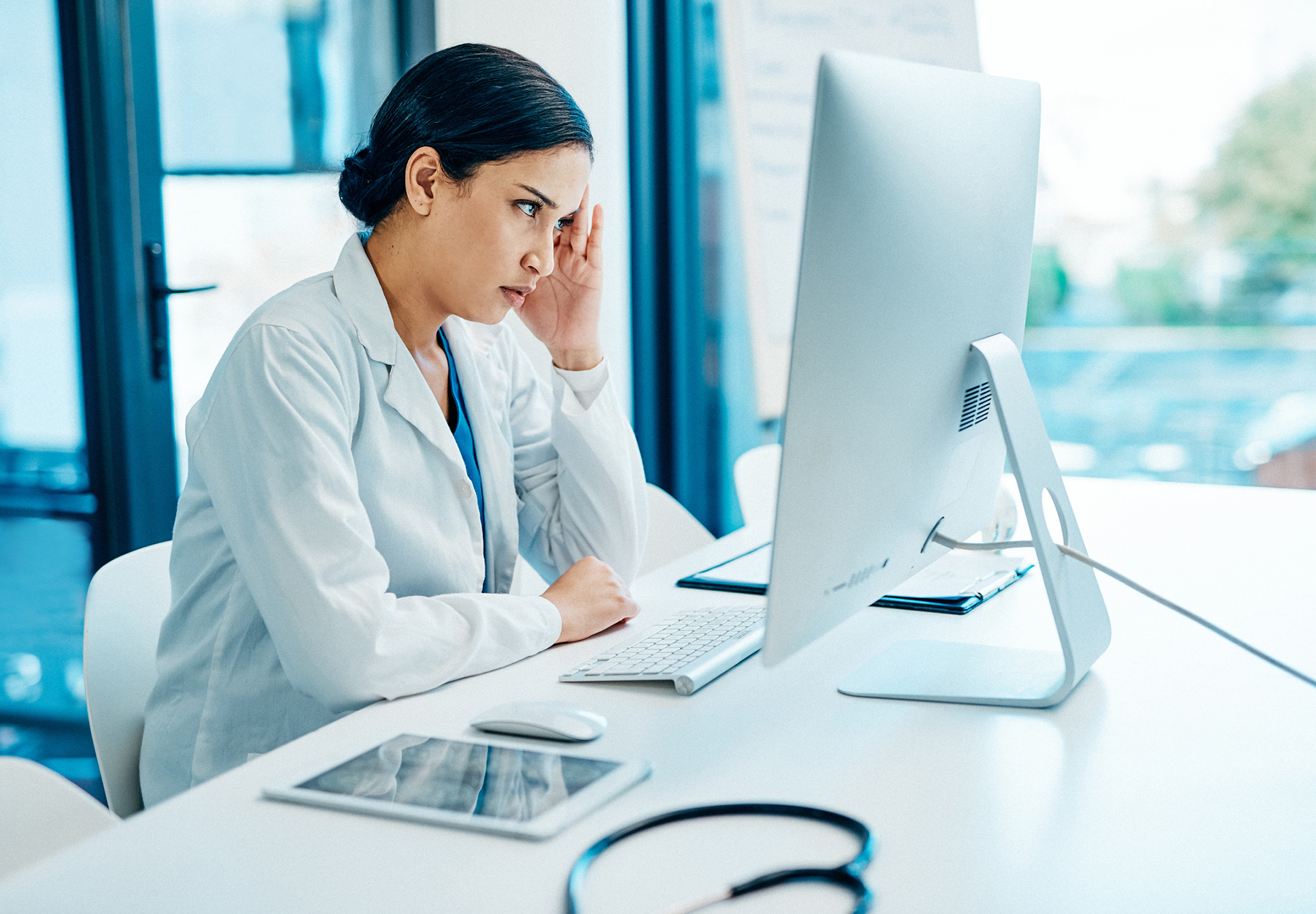 A stressed scientist looking at her computer.