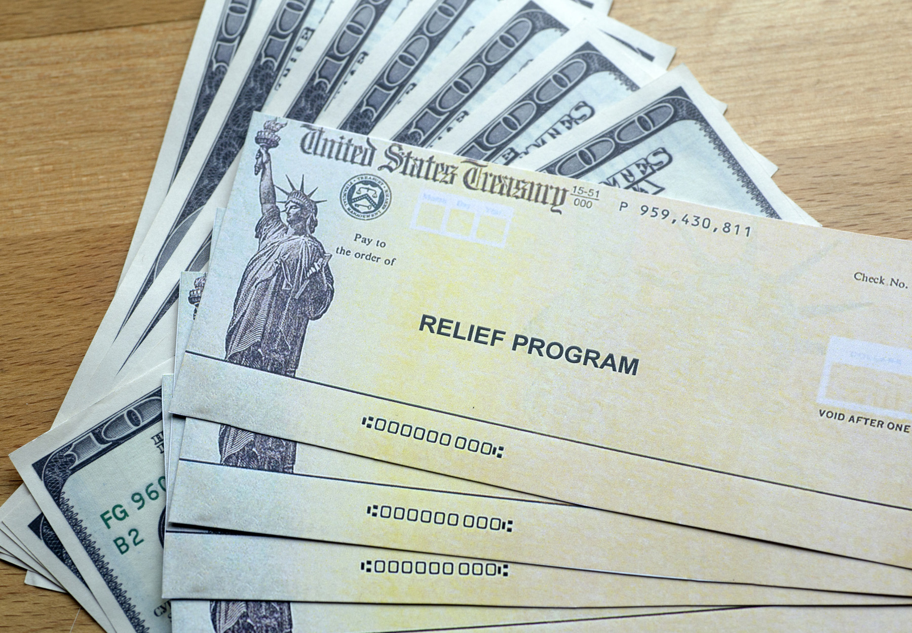 A collection of relief fund checks fanned out on a table.