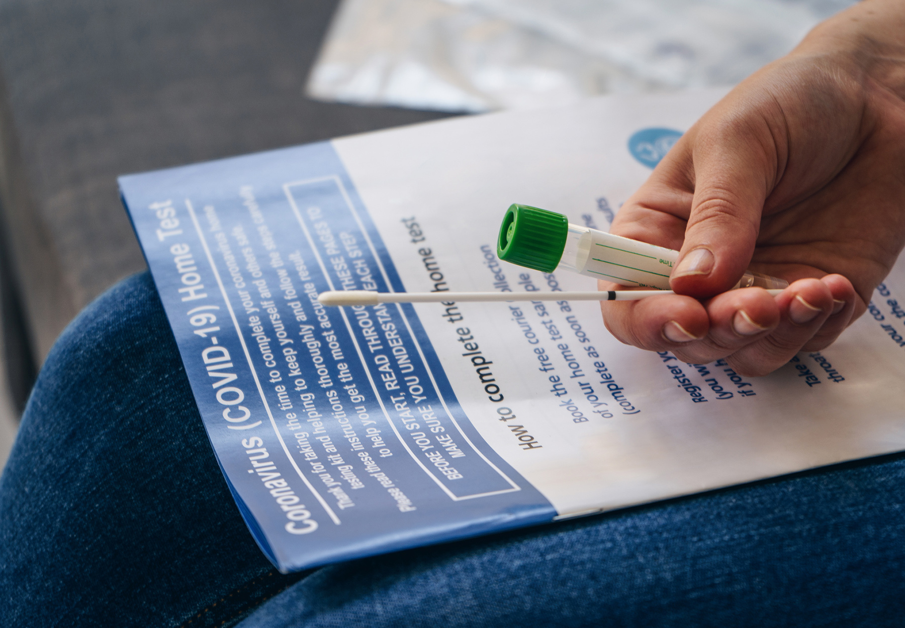 Young woman holds a swab and medical tube for the coronavirus / covid19 home test