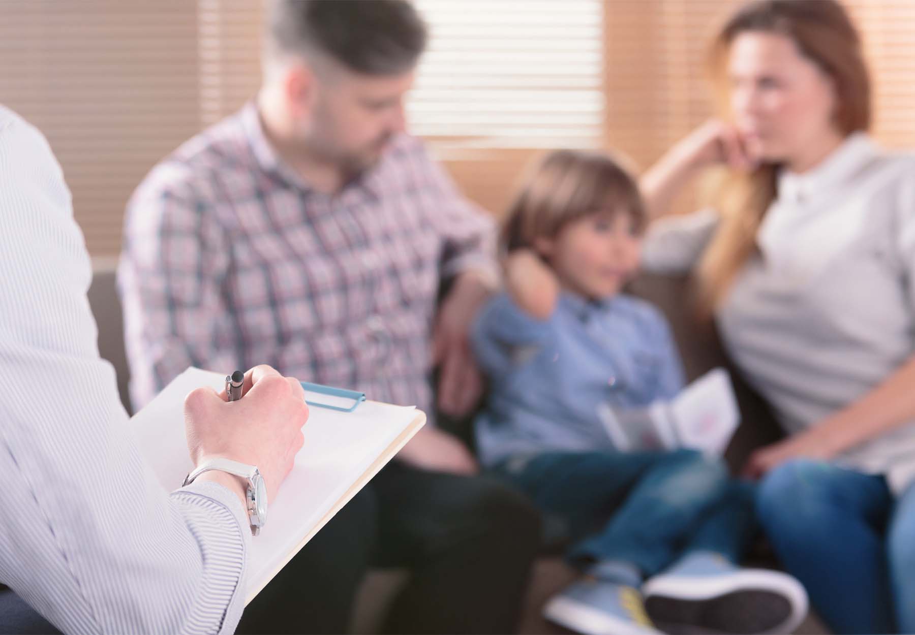 A child with his parents is being assessed by a doctor.