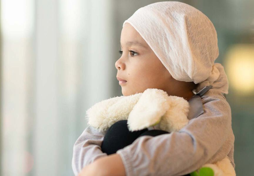 child cancer patient looking out a window