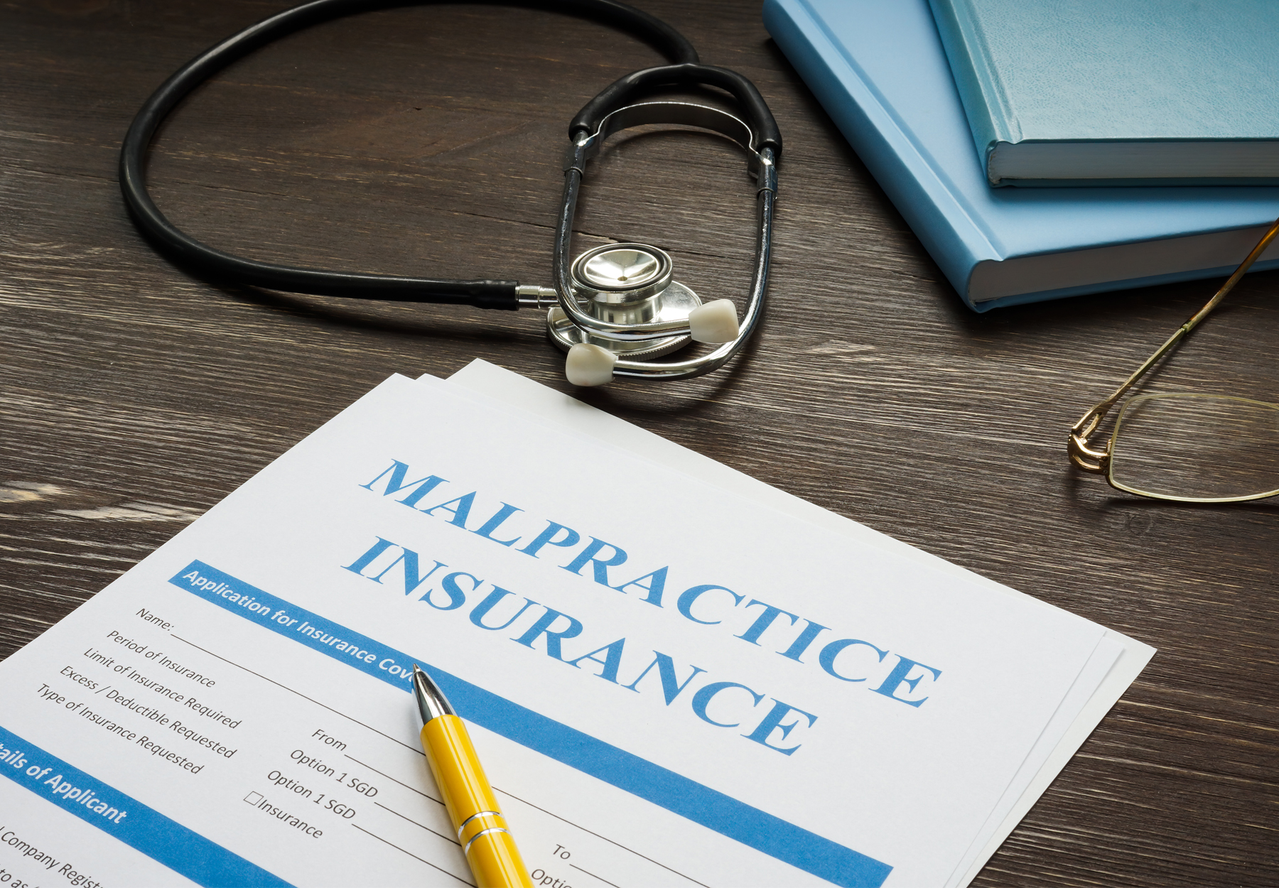 Image of application form for malpractice insurance on a physician's desk