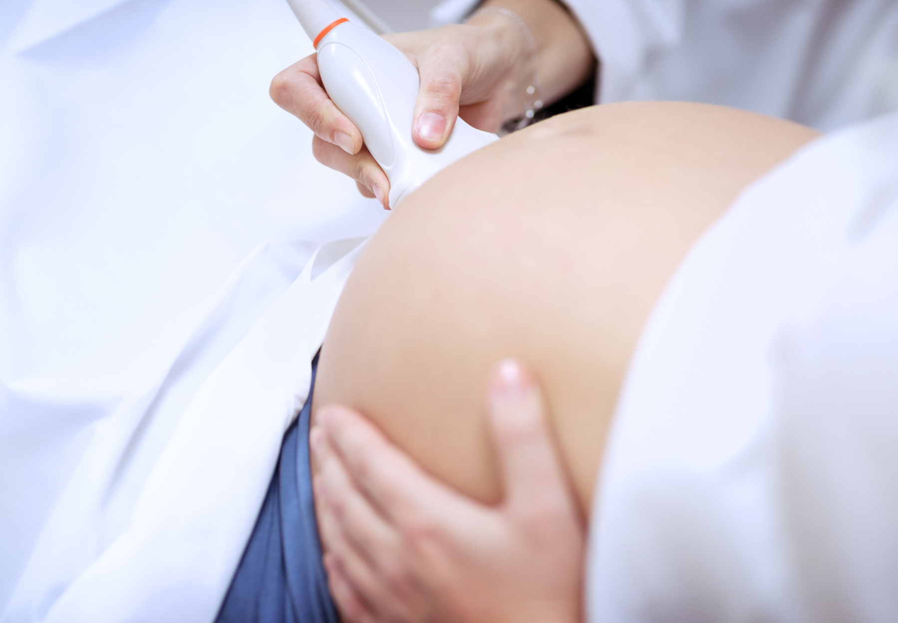 Doctor doing an ultrasound on a pregnant woman stock photo