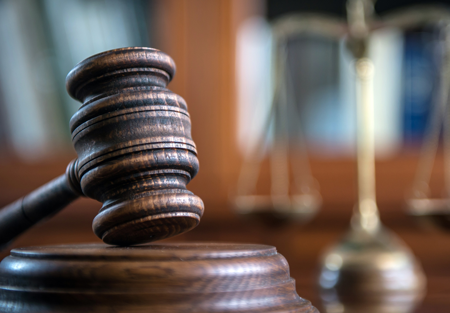 Law and Justice concept. Mallet of the judge, books, scales of justice. Gray stone background, reflections on the floor, place for typography. Courtroom theme.