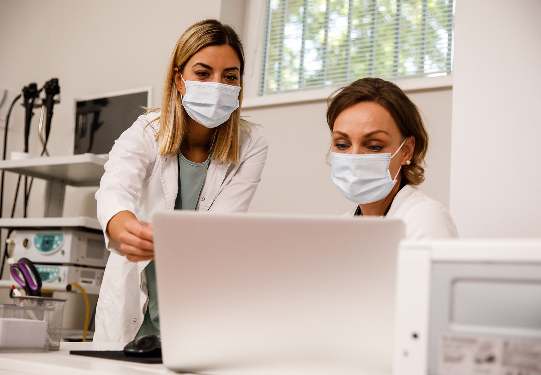 Two clinical lab staff members looking at laptop.