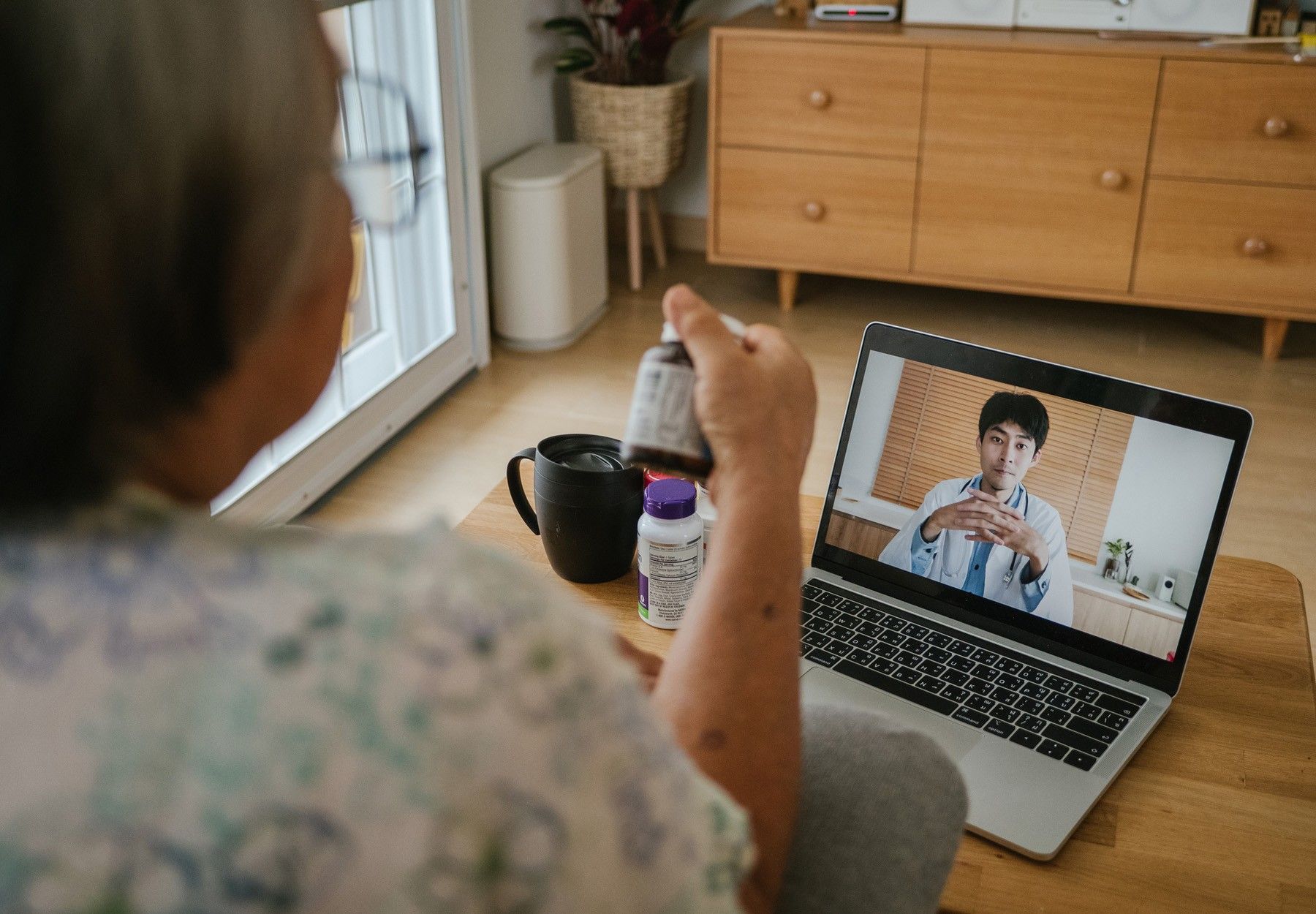A stock image of an elderly woman on a video telehealth appointment with her doctor