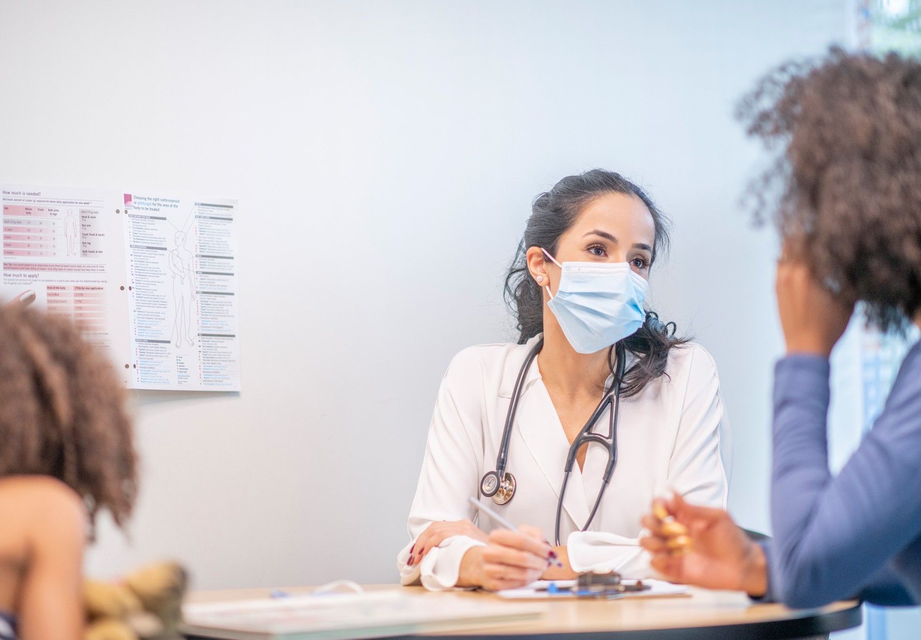 A woman, viewed from the back, meets with her medical counselor stock photo