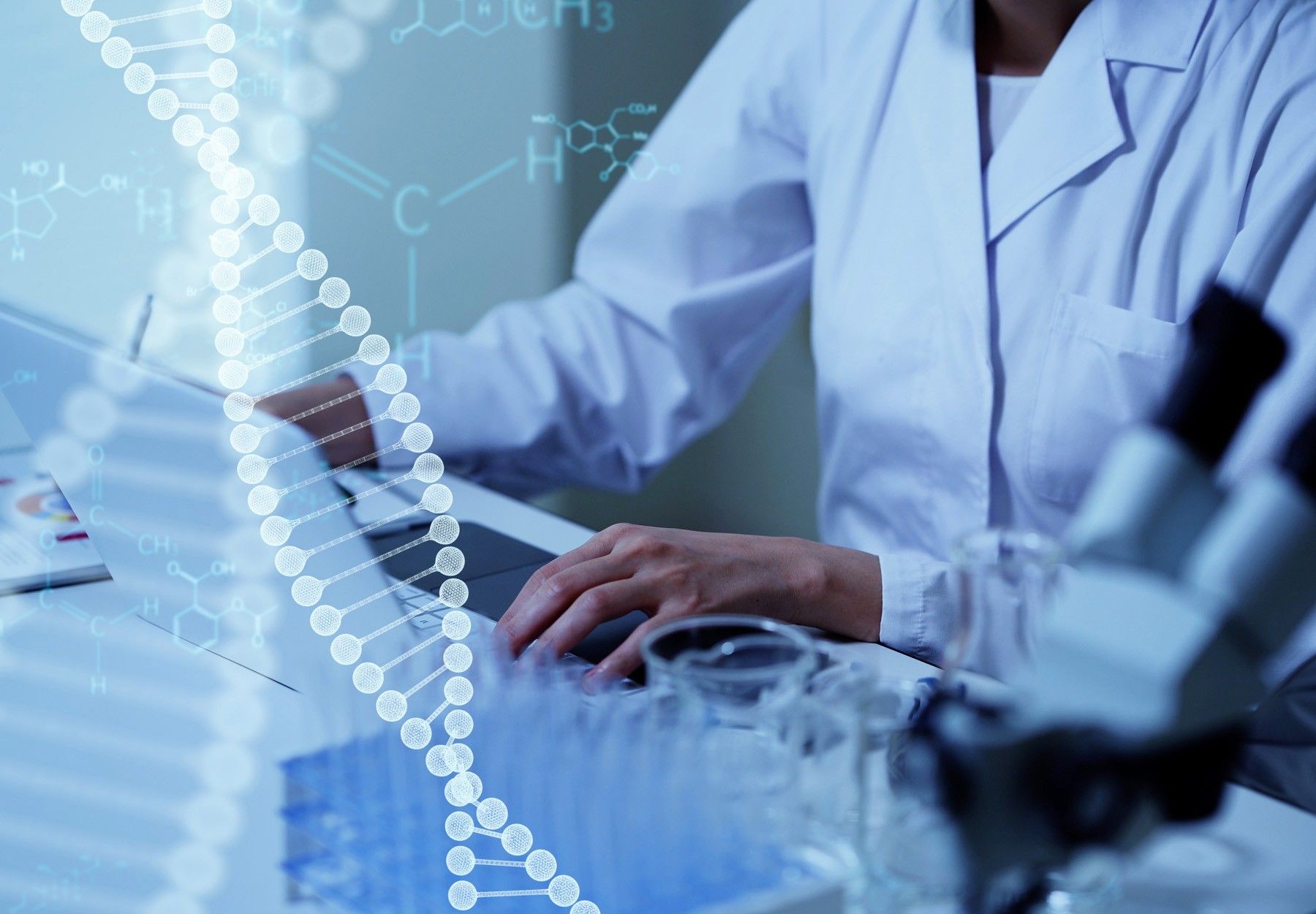 Closeup of lab worker typing on computer with DNA illustration overlay to represent diagnostics market