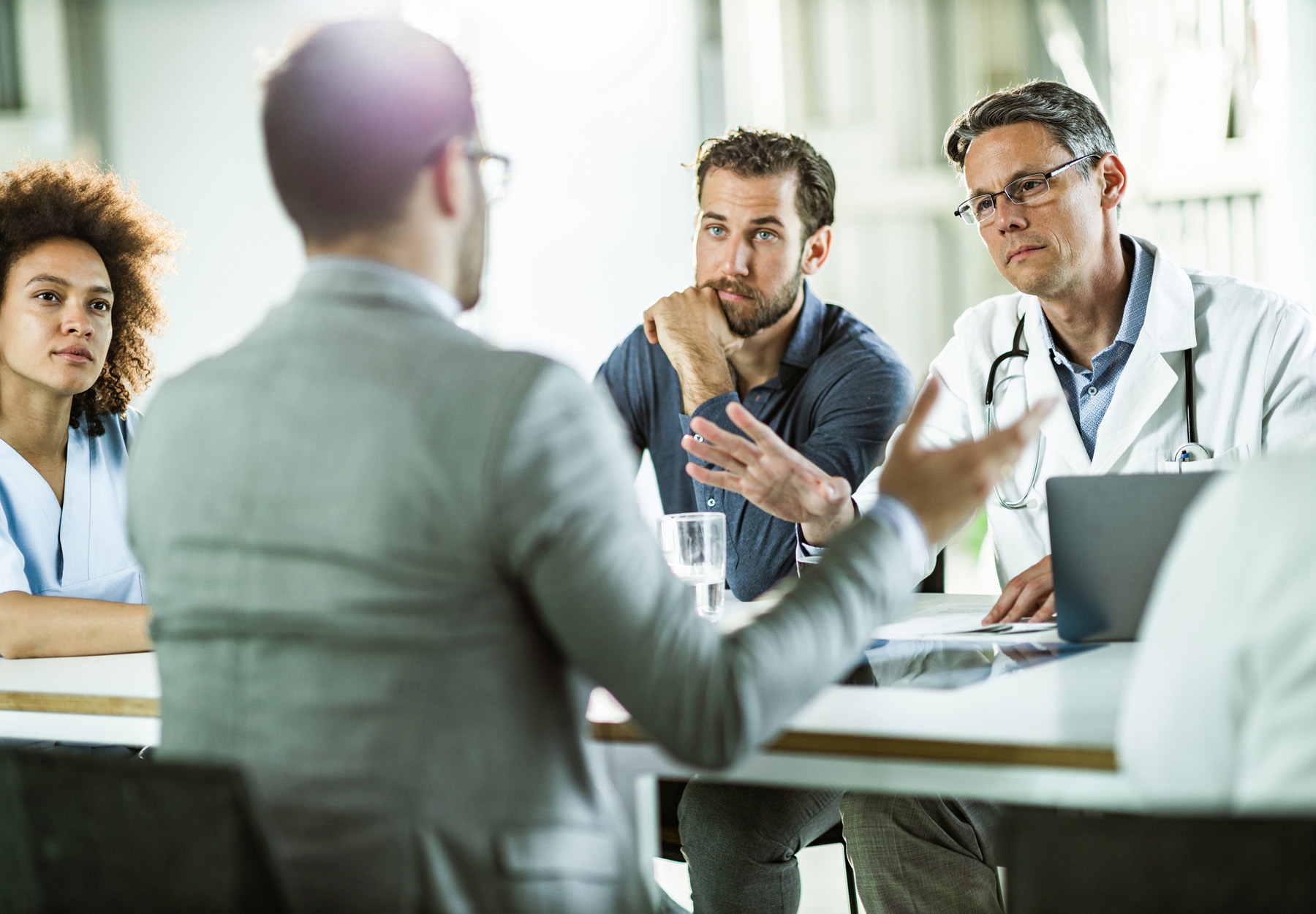 Businesspeople and hospital staff discussing merger