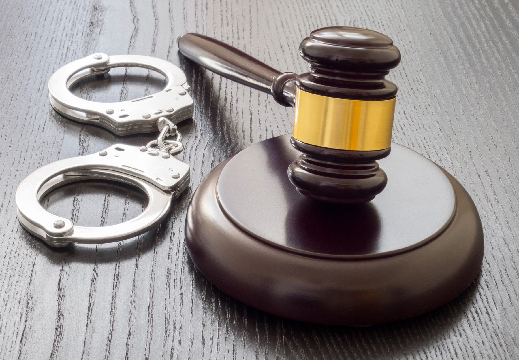 gavel and handcuffs resting on a desk