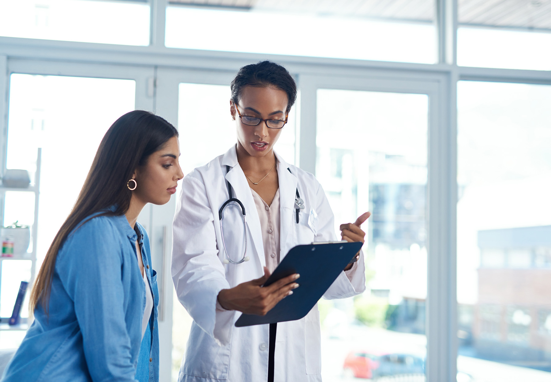 Doctor showing a form on a clipboard to a patient