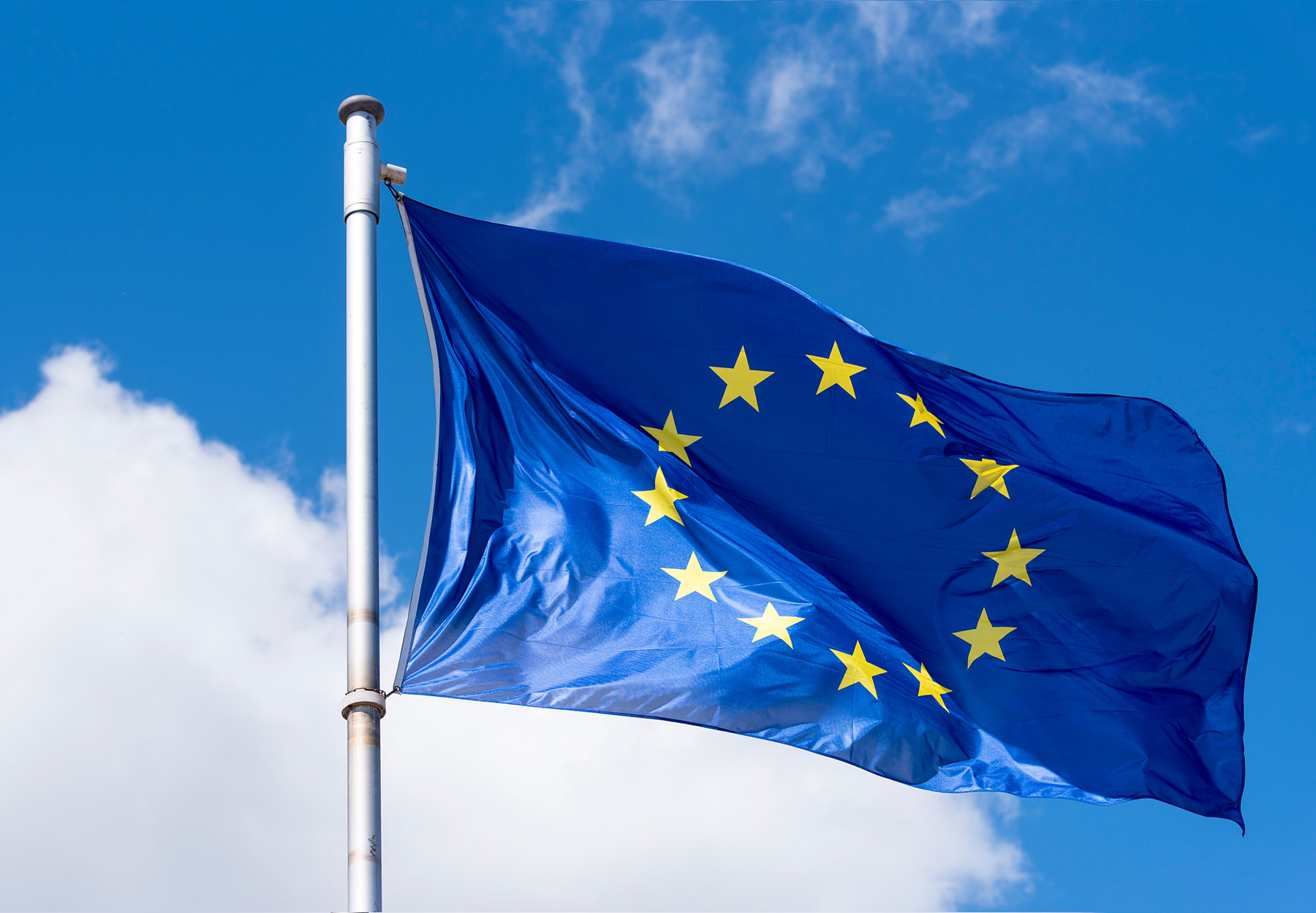 A closeup of the European Union flag against a blue sky