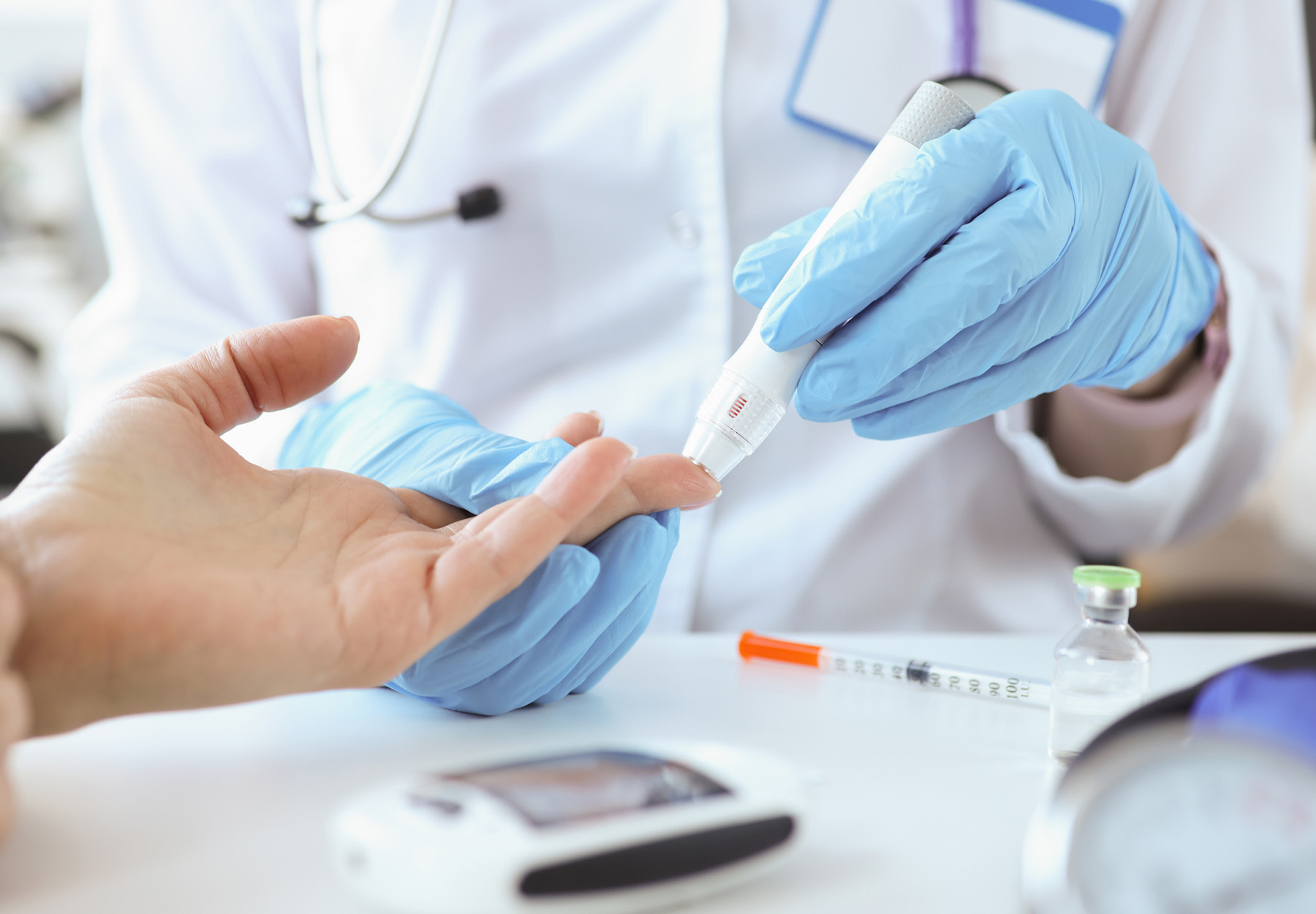 Doctor with gloves piercing patient's finger with lancet closeup stock photo