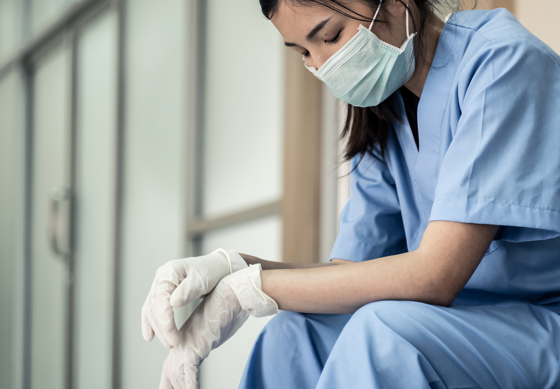 Stock image of stressed nurse sitting in hospital