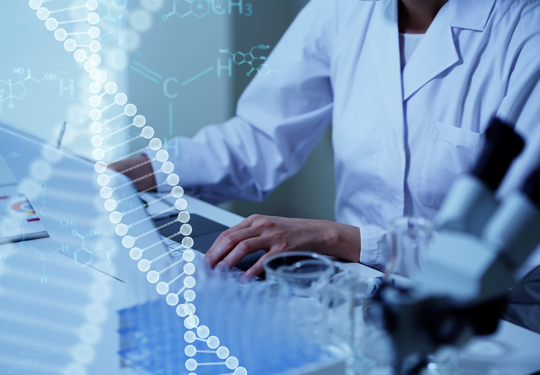 a photo illustration of a cropped lab worker typing on a computer with DNA strands and chemical formulas over top.