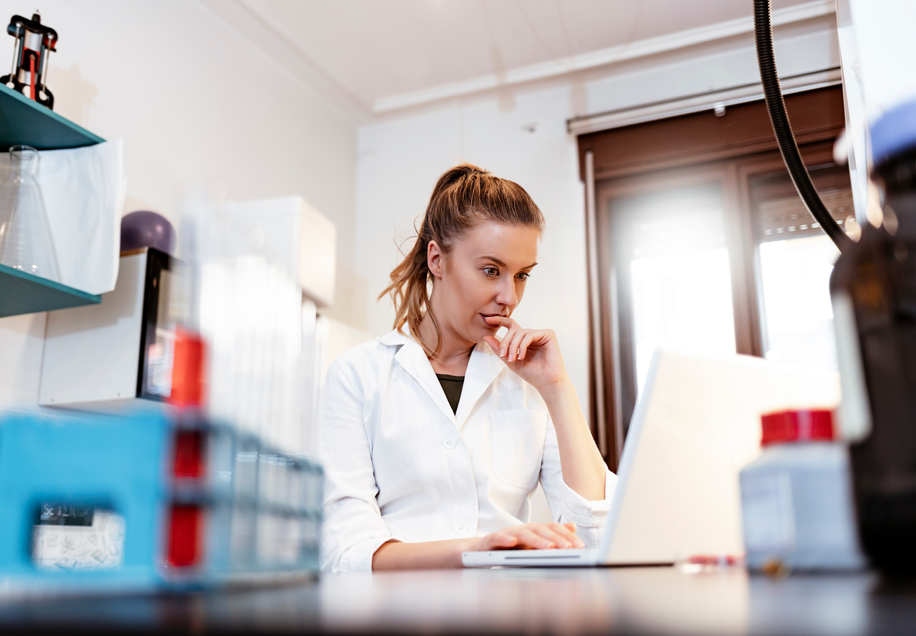 A female lab professional using a computer in the laboratory.