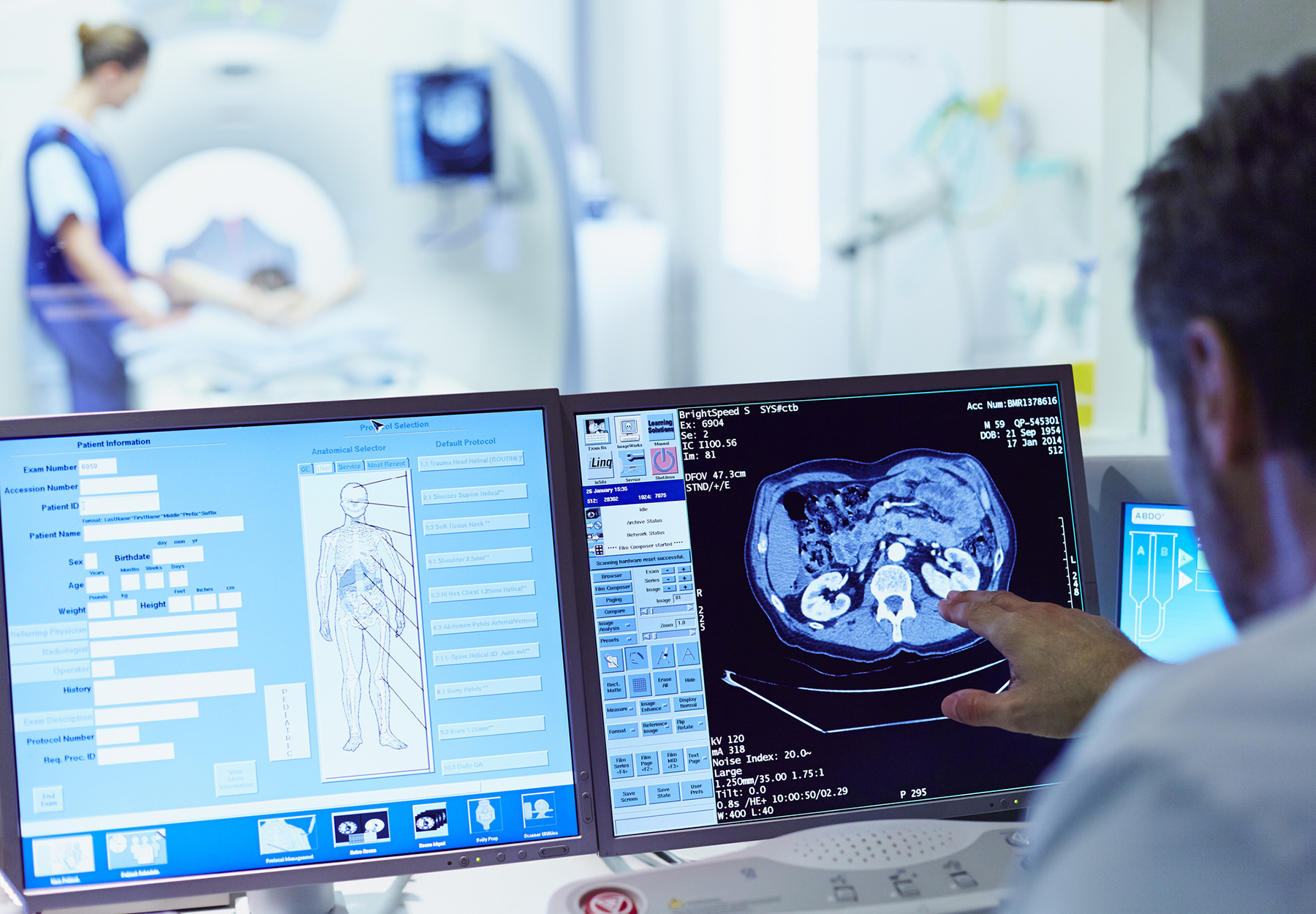 Doctor running CT scan from control room stock photo