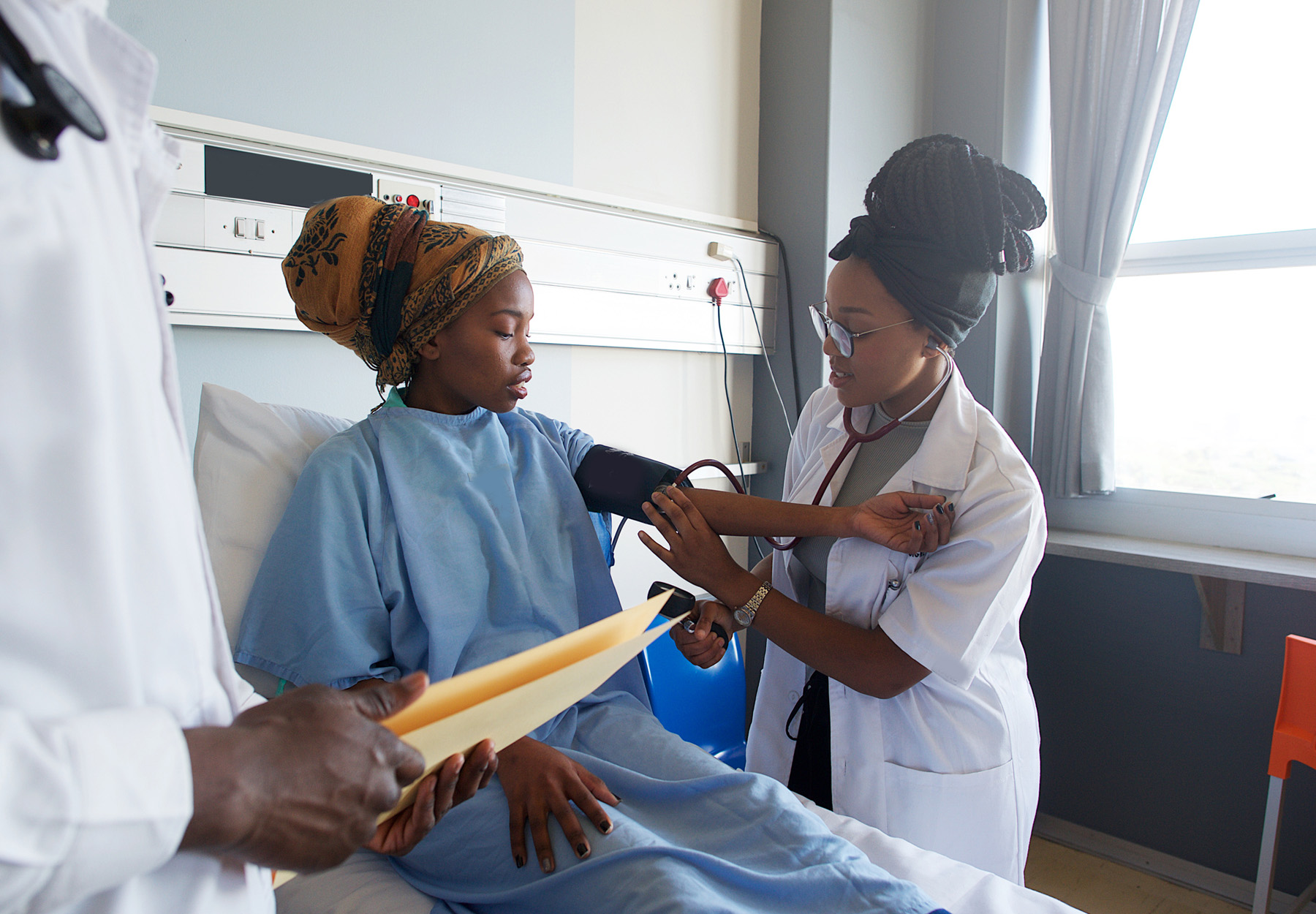 Health care worker does blood pressure test on patient in South Africa stock photo