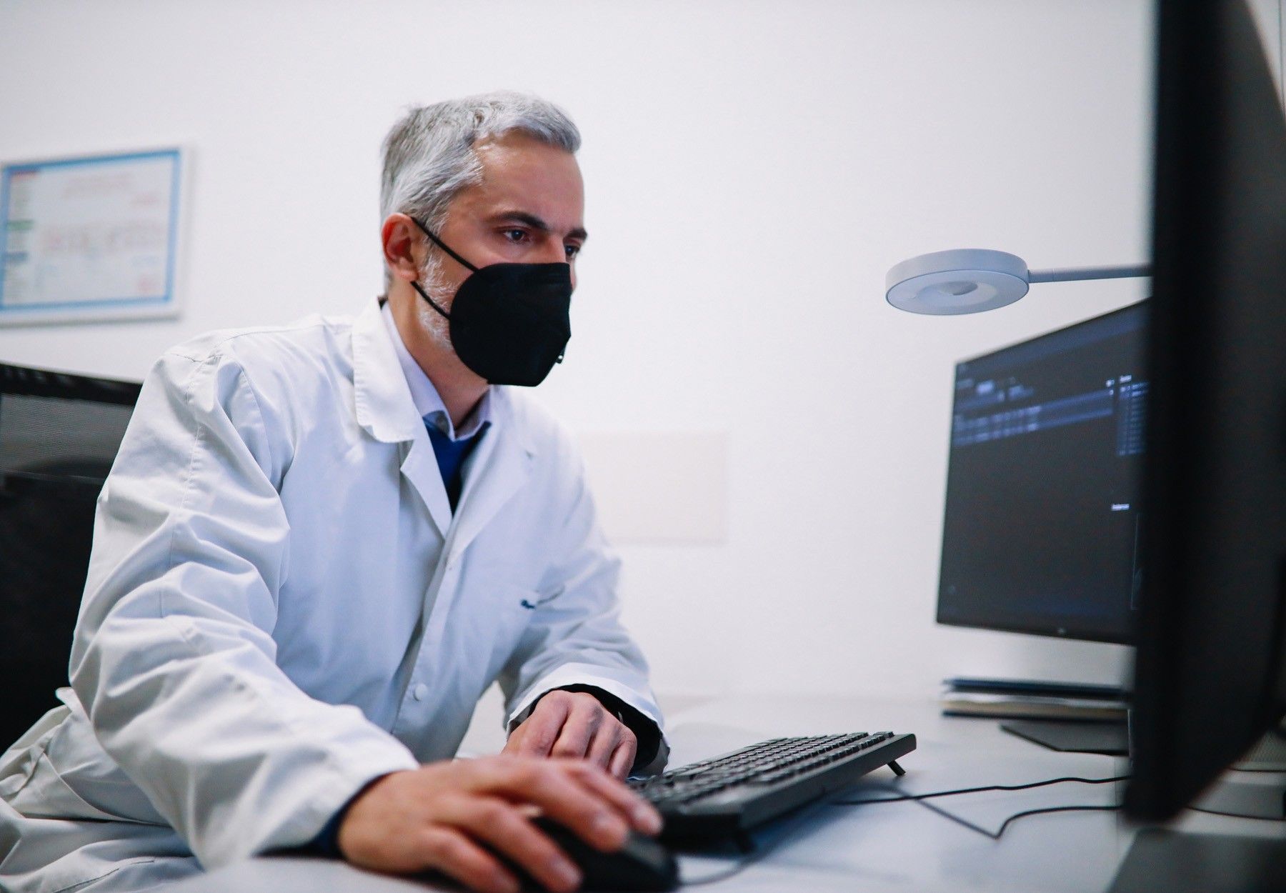 Mid age doctor working on medical data in the hospital stock photo