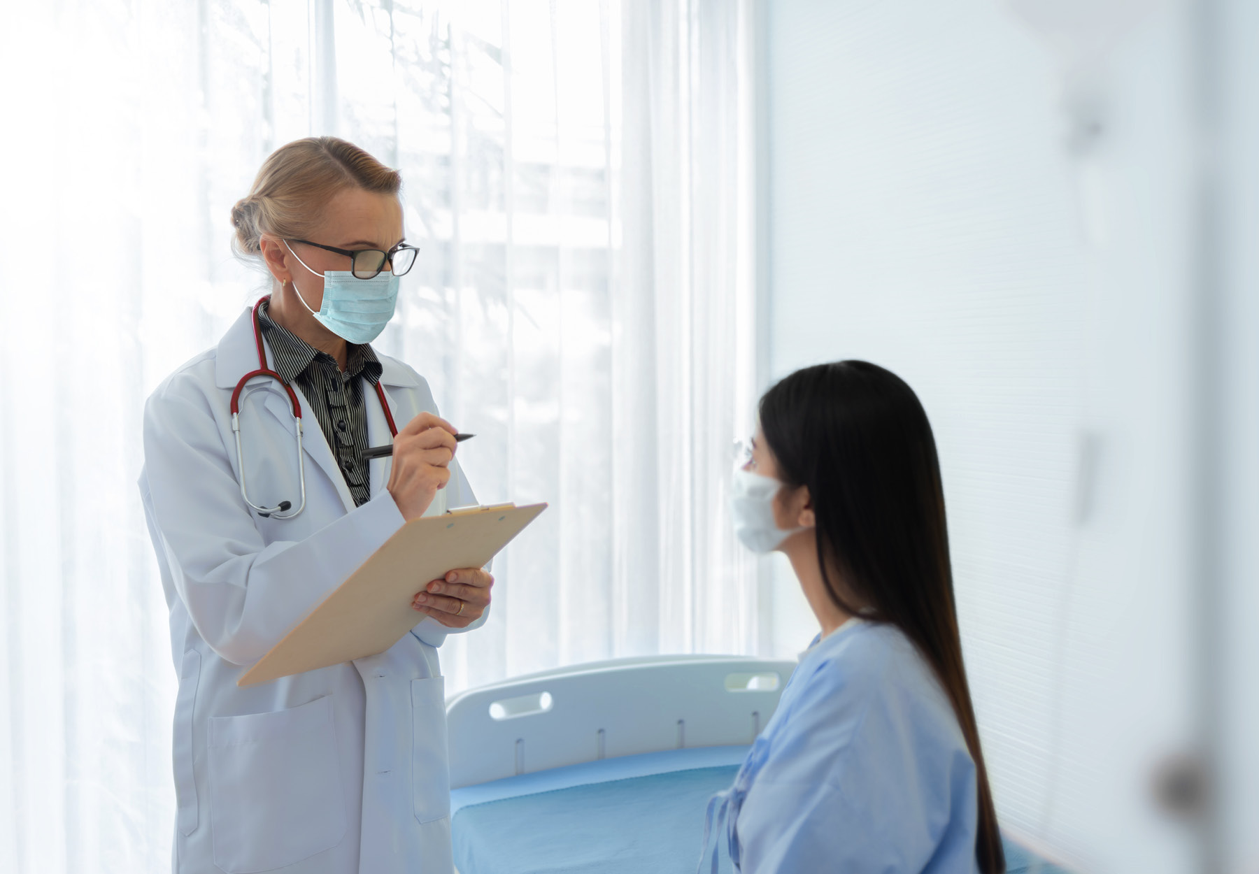 Stock image of a female patient meeting with her doctor in a hospital room