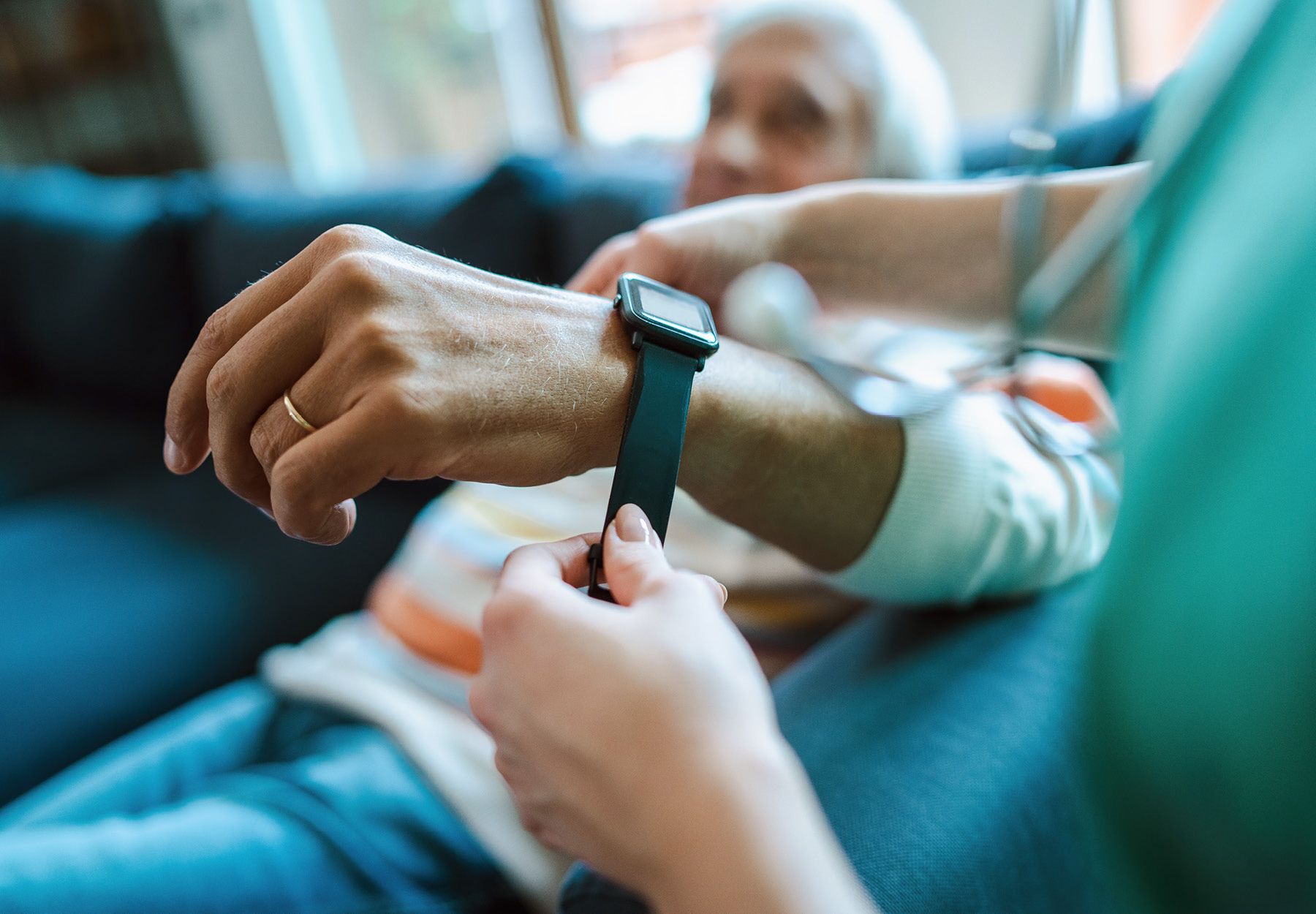 Health care worker placing a smart watch on an elderly person's wrist stock photo