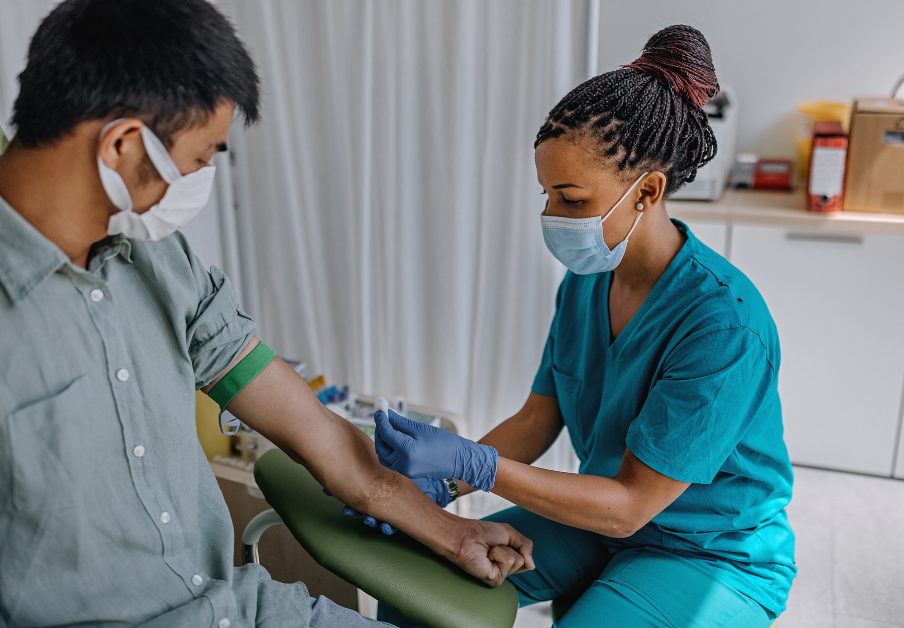 Nurse preparing male patient to do a blood analysis