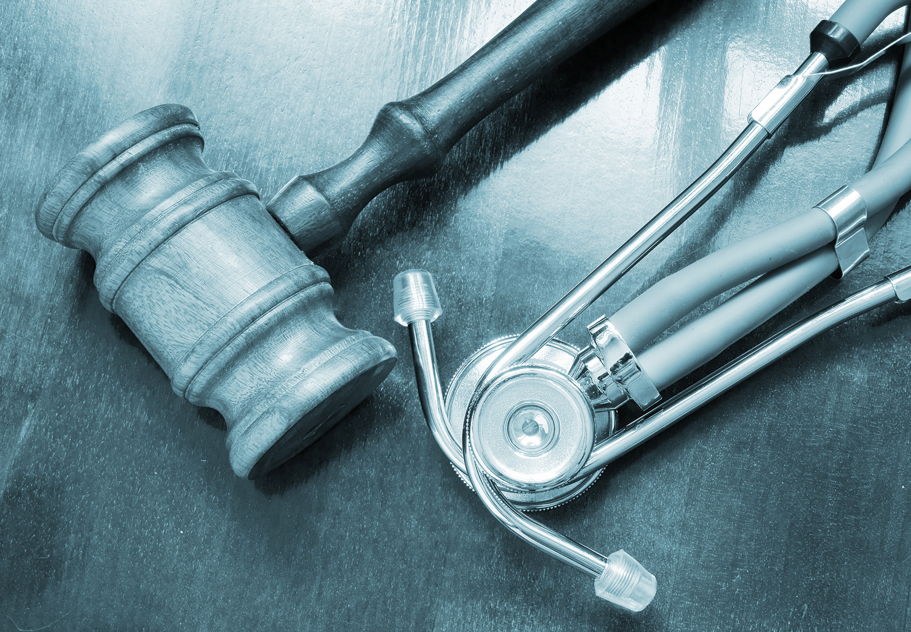 Wooden judge's gavel and stethoscope on wooden table stock image to represent actions against healthcare fraud
