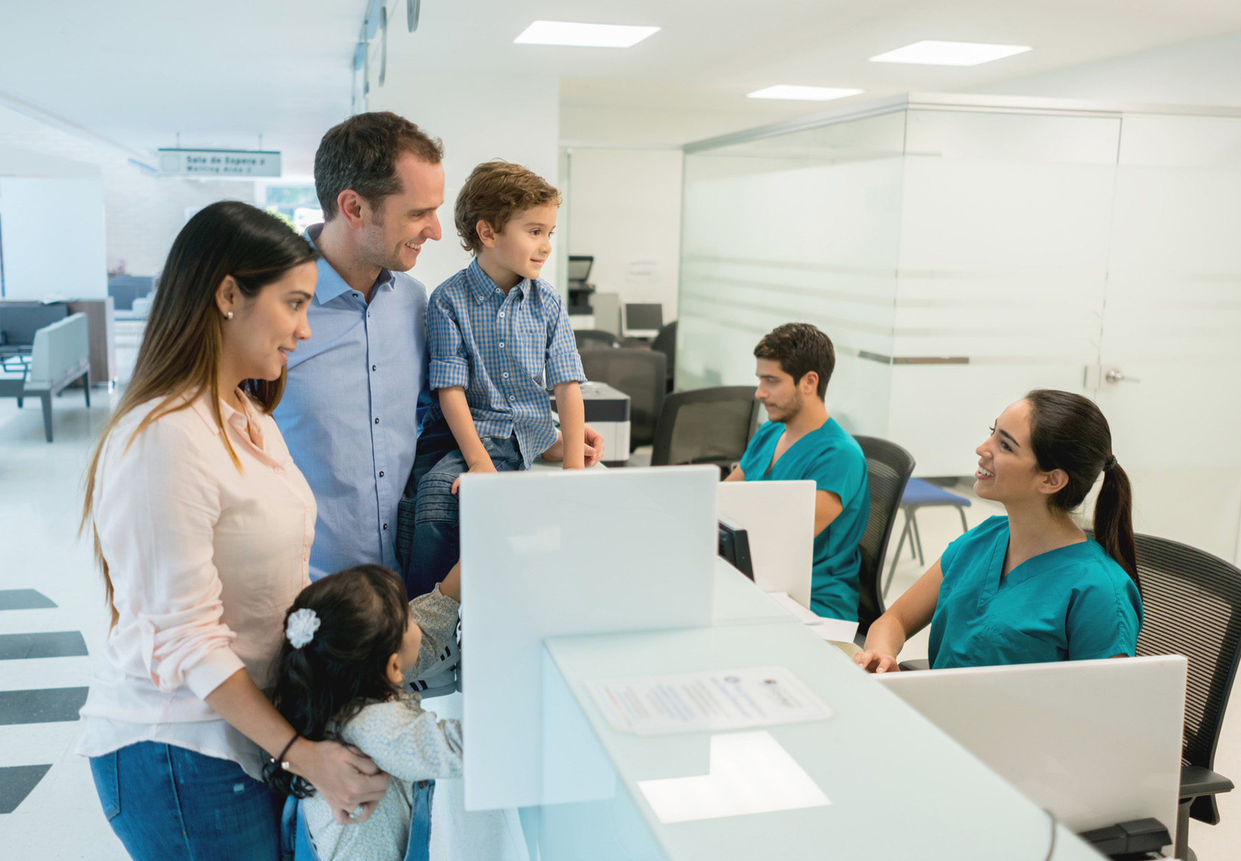 Family at front desk of hospital. Stock photo.