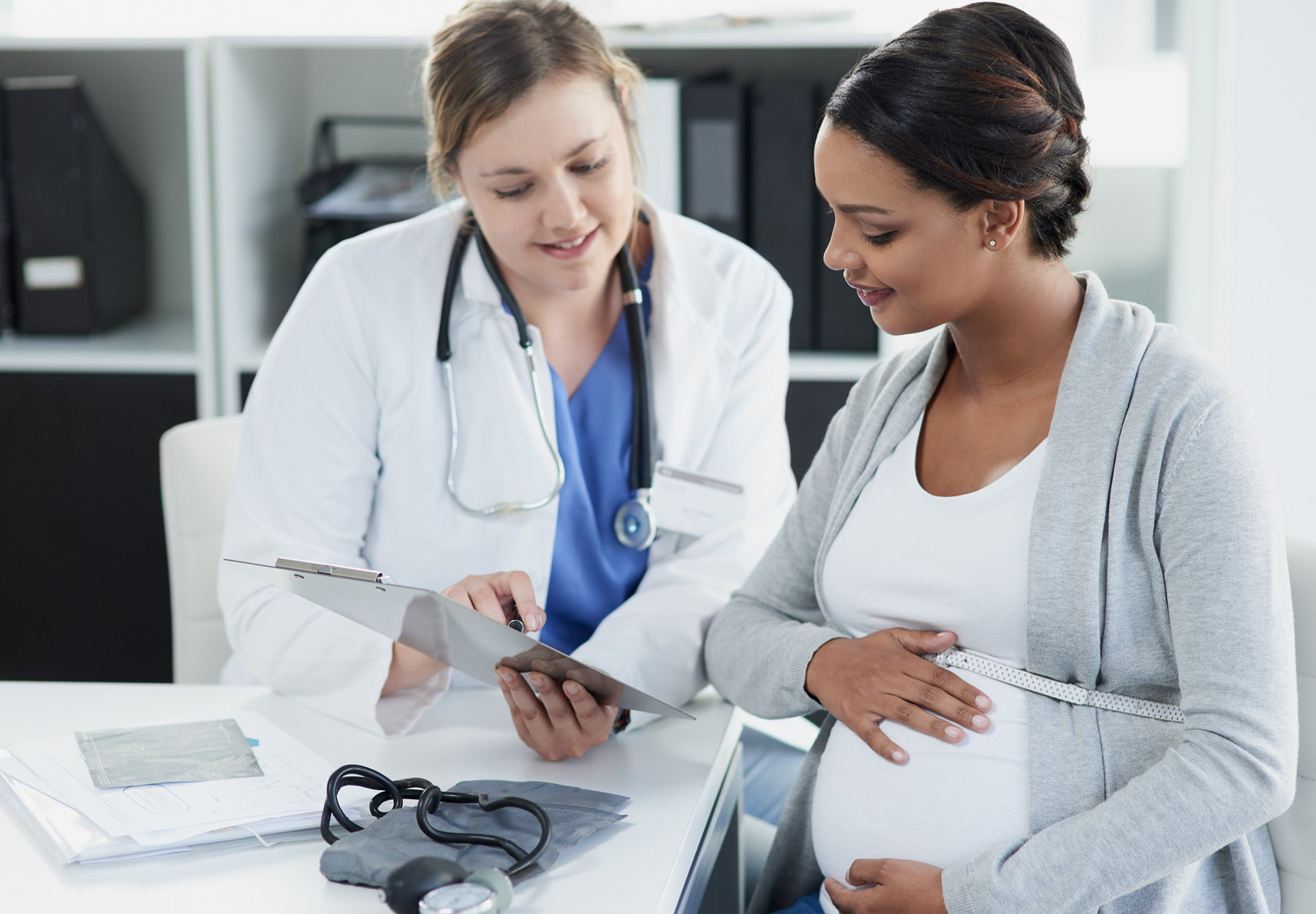 Pregnant woman meeting with her doctor. Stock image.