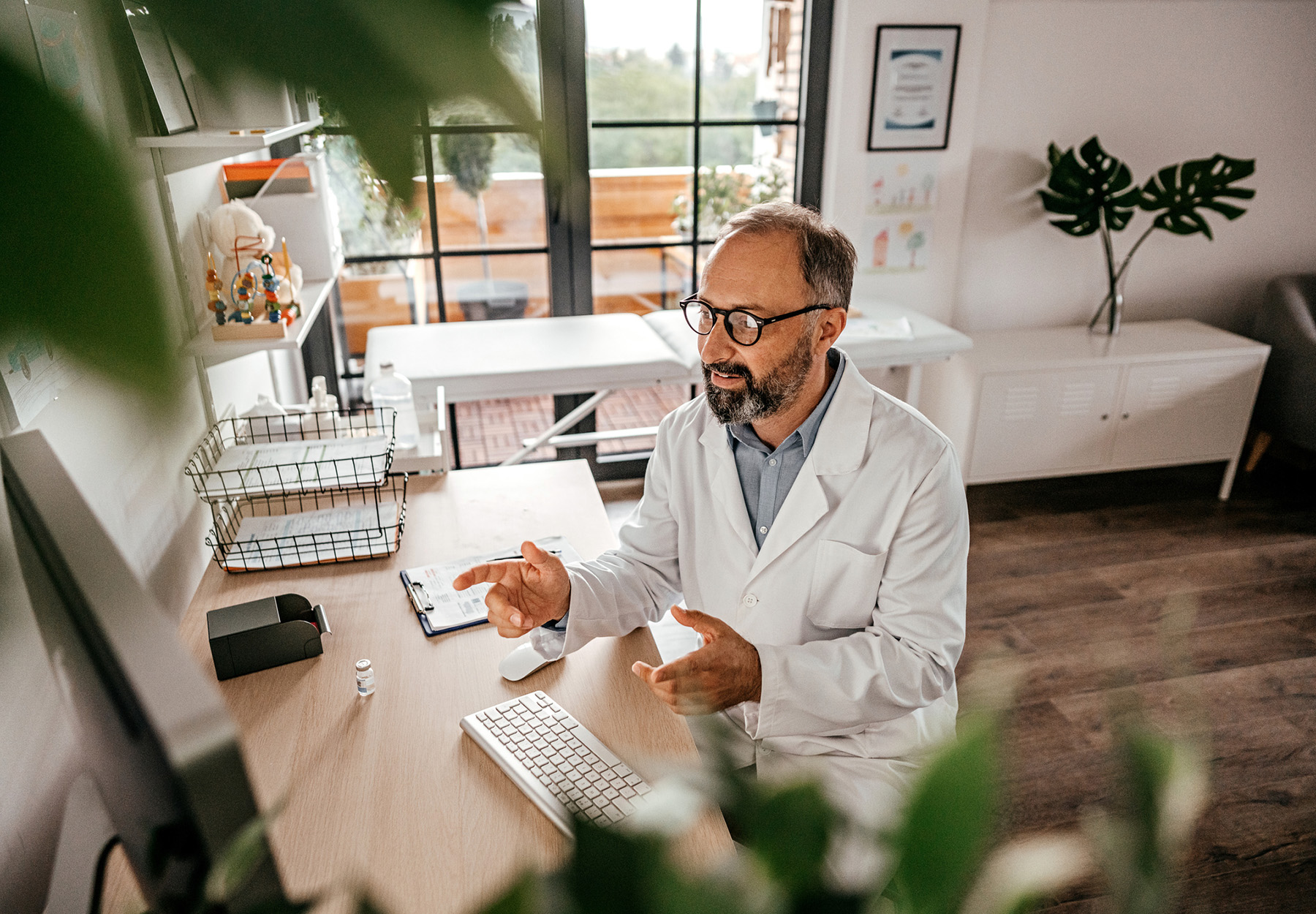 Doctor from a medical clinic is having a video meeting with his patient. Stock image.