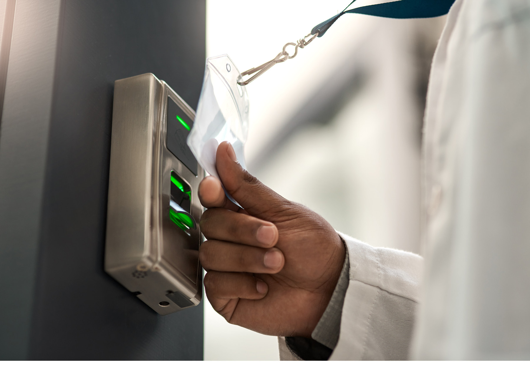 Closeup photo of someone in a lab coat swiping a key card.