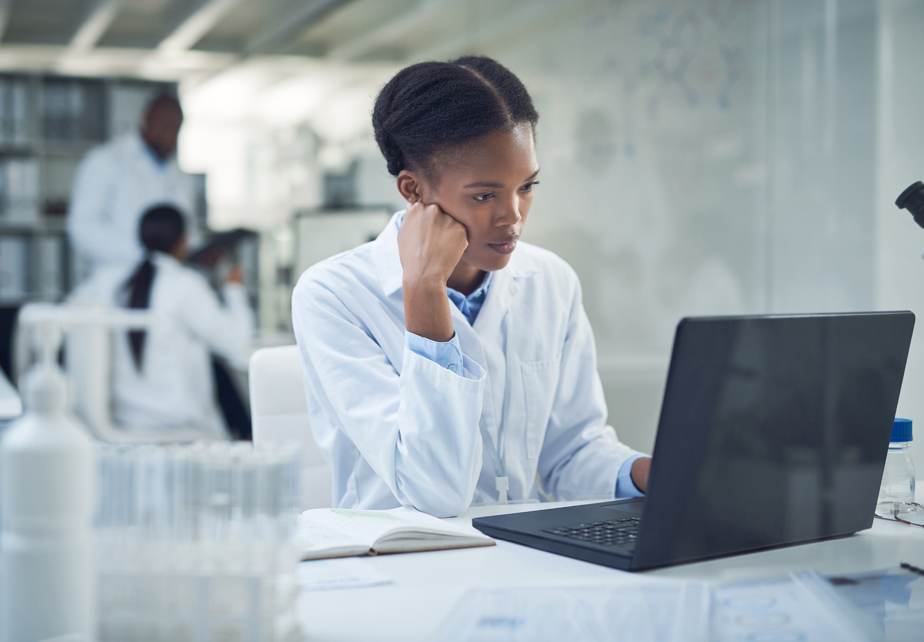 African American female lab employee looking at her laptop with a stressed expression. Stock photo.