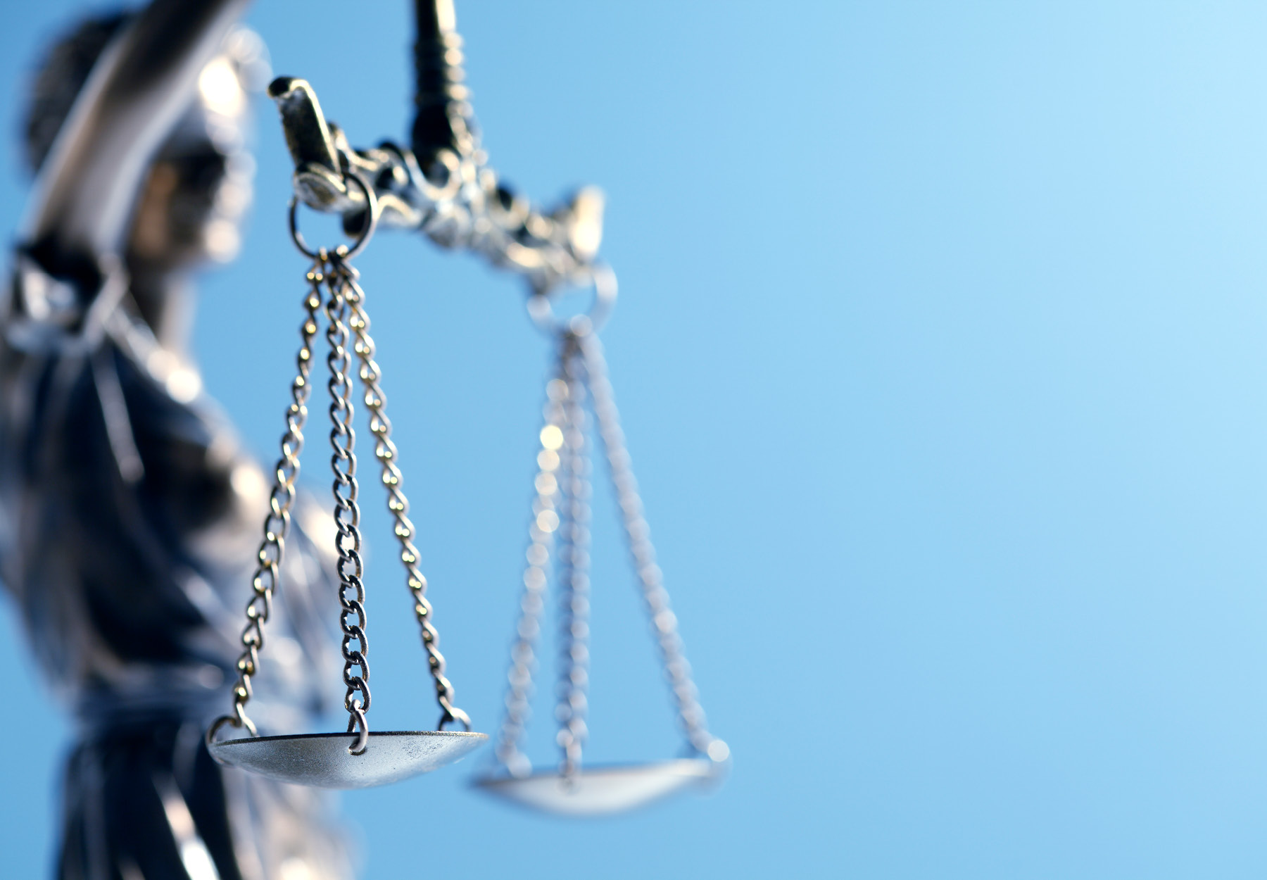 Closeup of silver lady justice statue on a blue background. Court concept. Stock image.