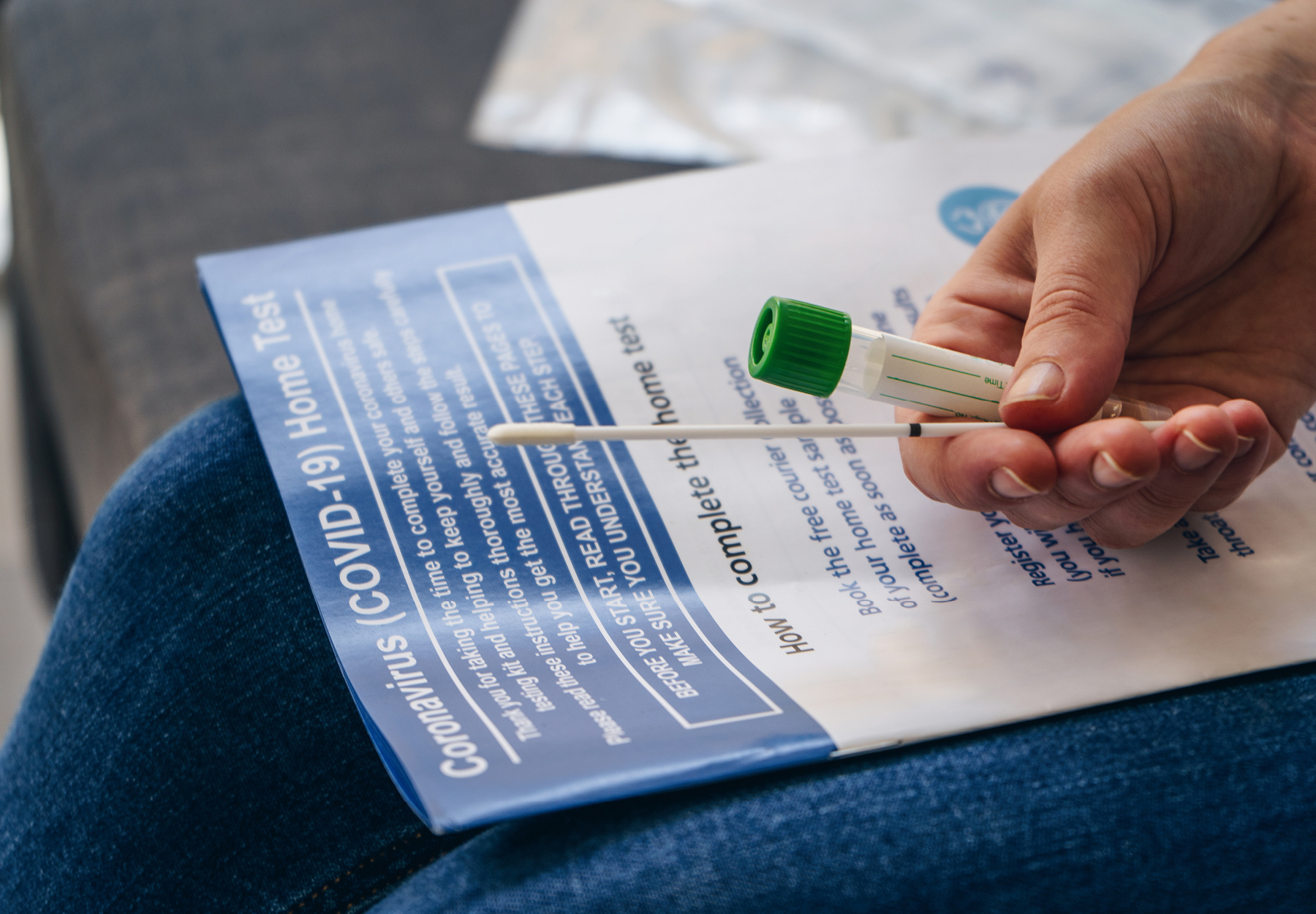 Young woman holds a swab and medical tube for a COVID-19 test. Stock photo.