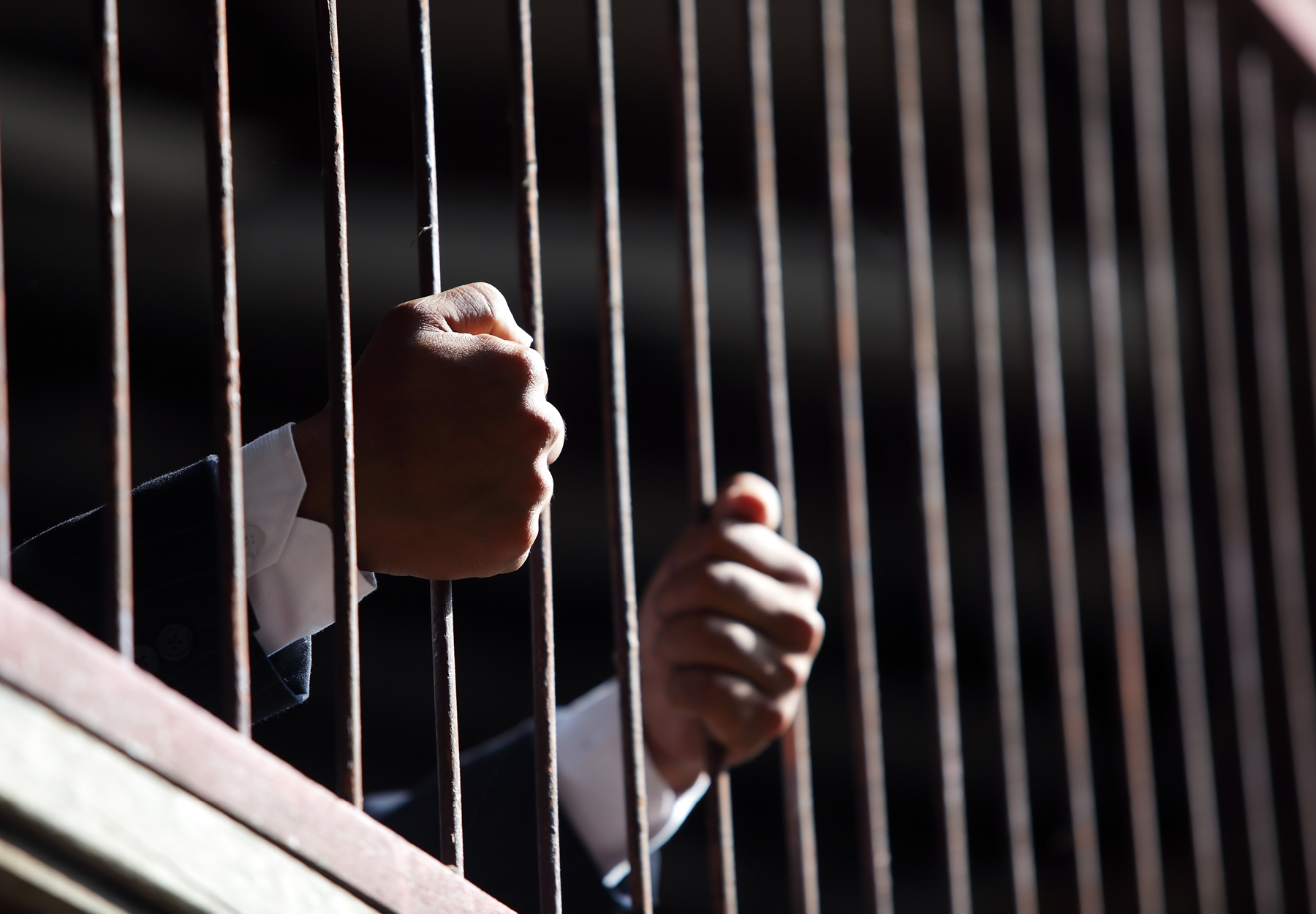 hands of businessman in jail. Stock image.