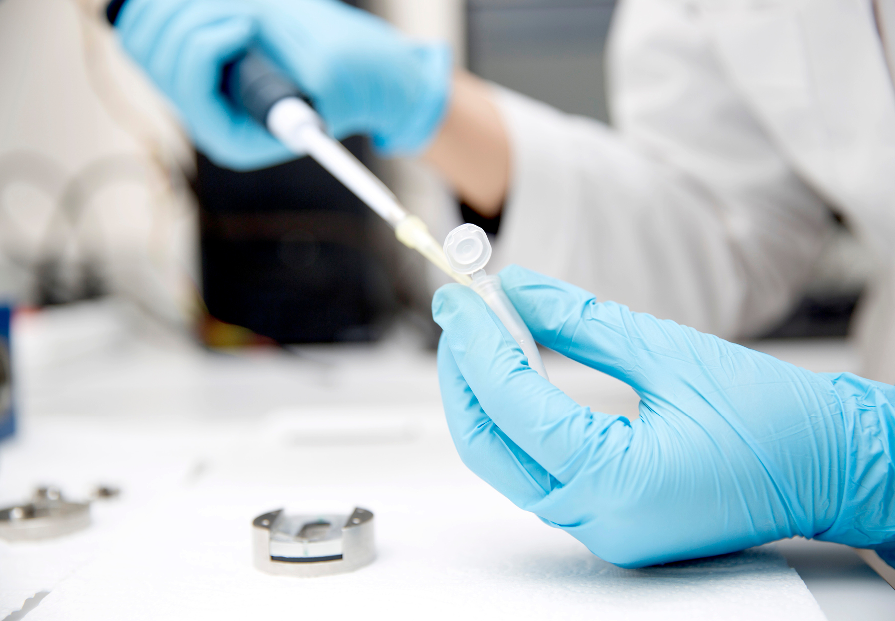 Closeup of lab worker pipetting during a medical lab test. iStock image.