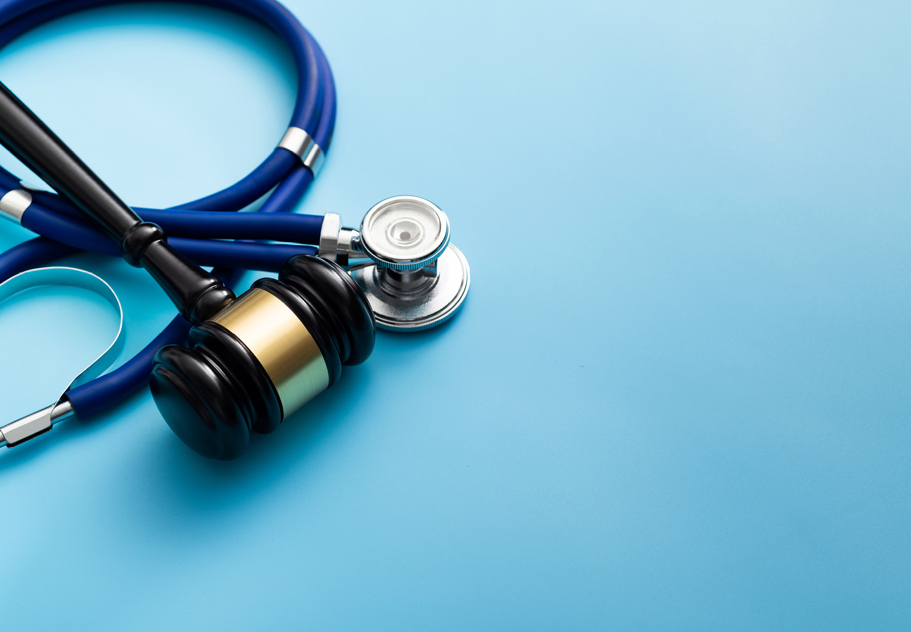 Gavel and stethoscope on blue background stock photo. iStock image.