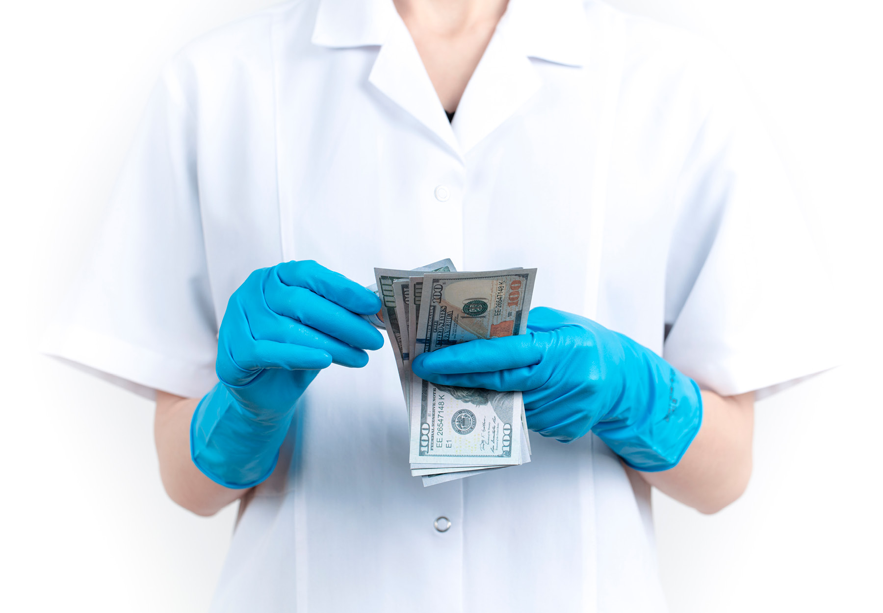 Hands of healthcare or lab worker counting US dollar bills. Healthcare fraud concept. iStock image.