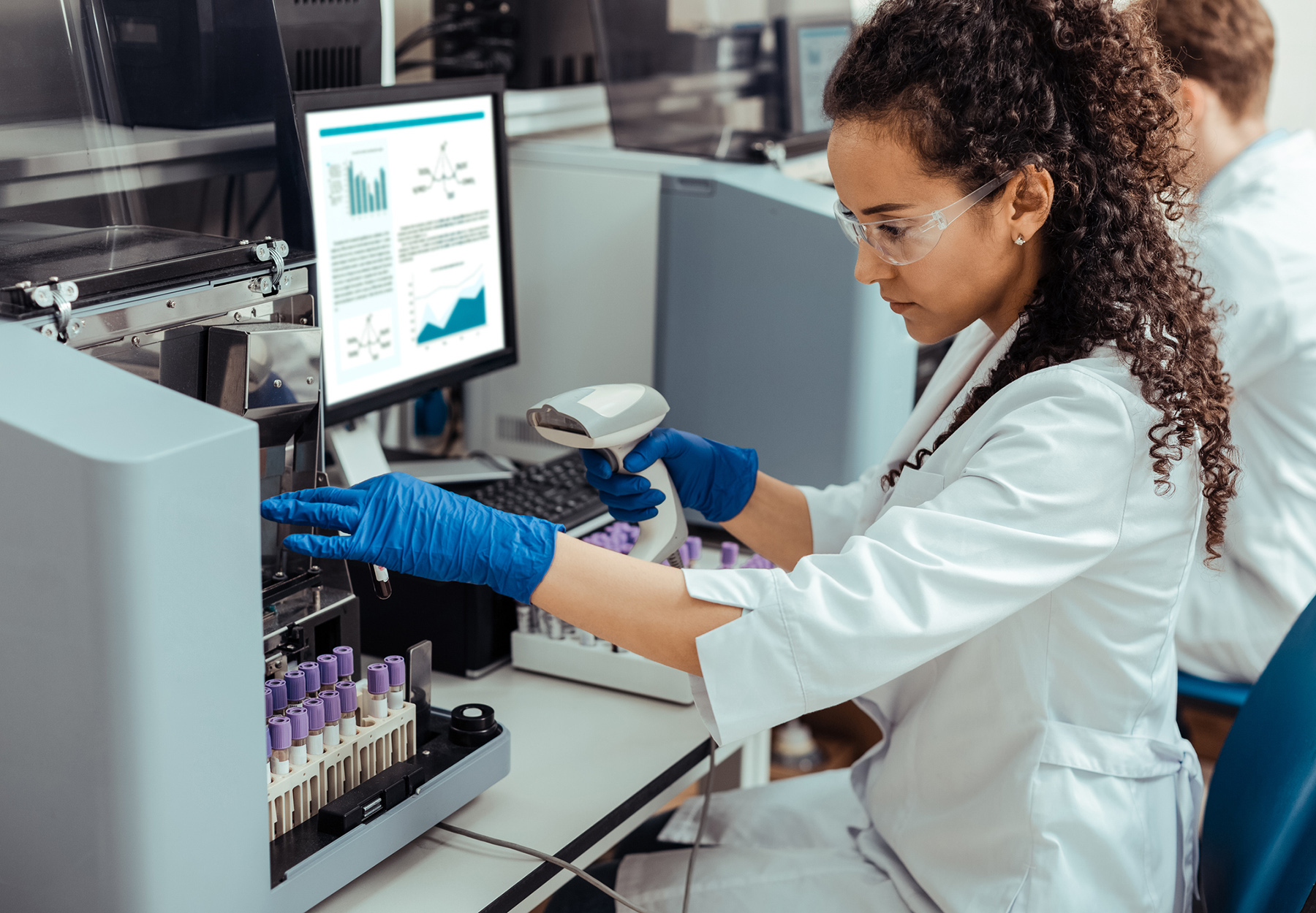 Laboratory technician looking at test tube iStock image