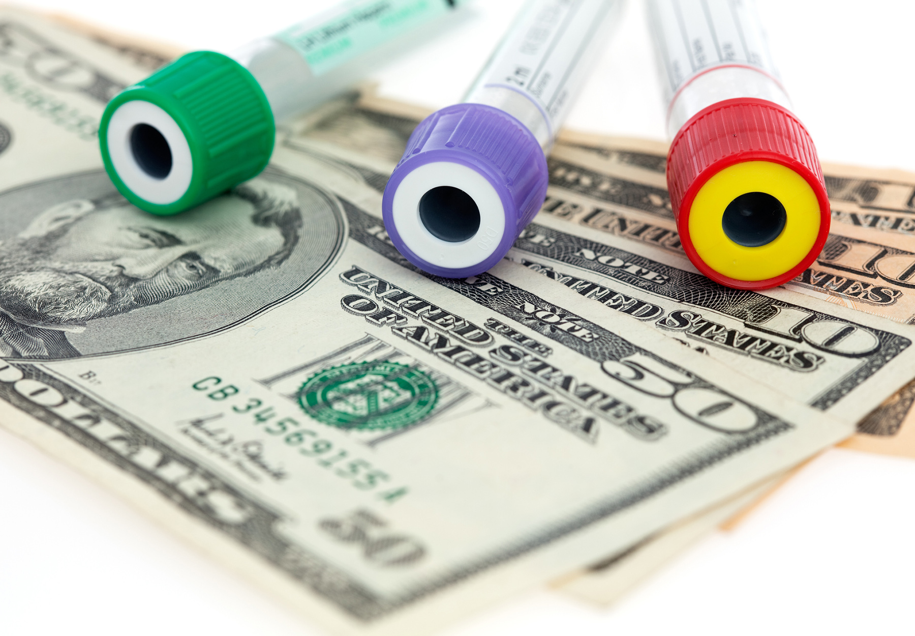 Medical expenses laboratory costs tubes on dollar bills iStock image